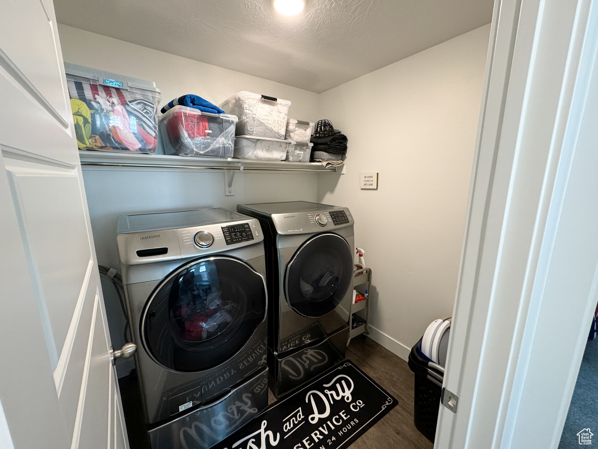 Clothes washing area featuring dark wood-type flooring, a textured ceiling, and washer and dryer