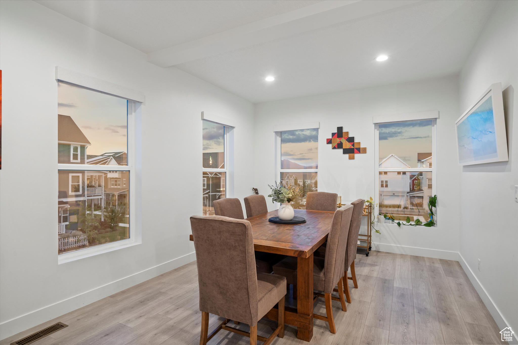 Dining space with beamed ceiling and light hardwood / wood-style floors