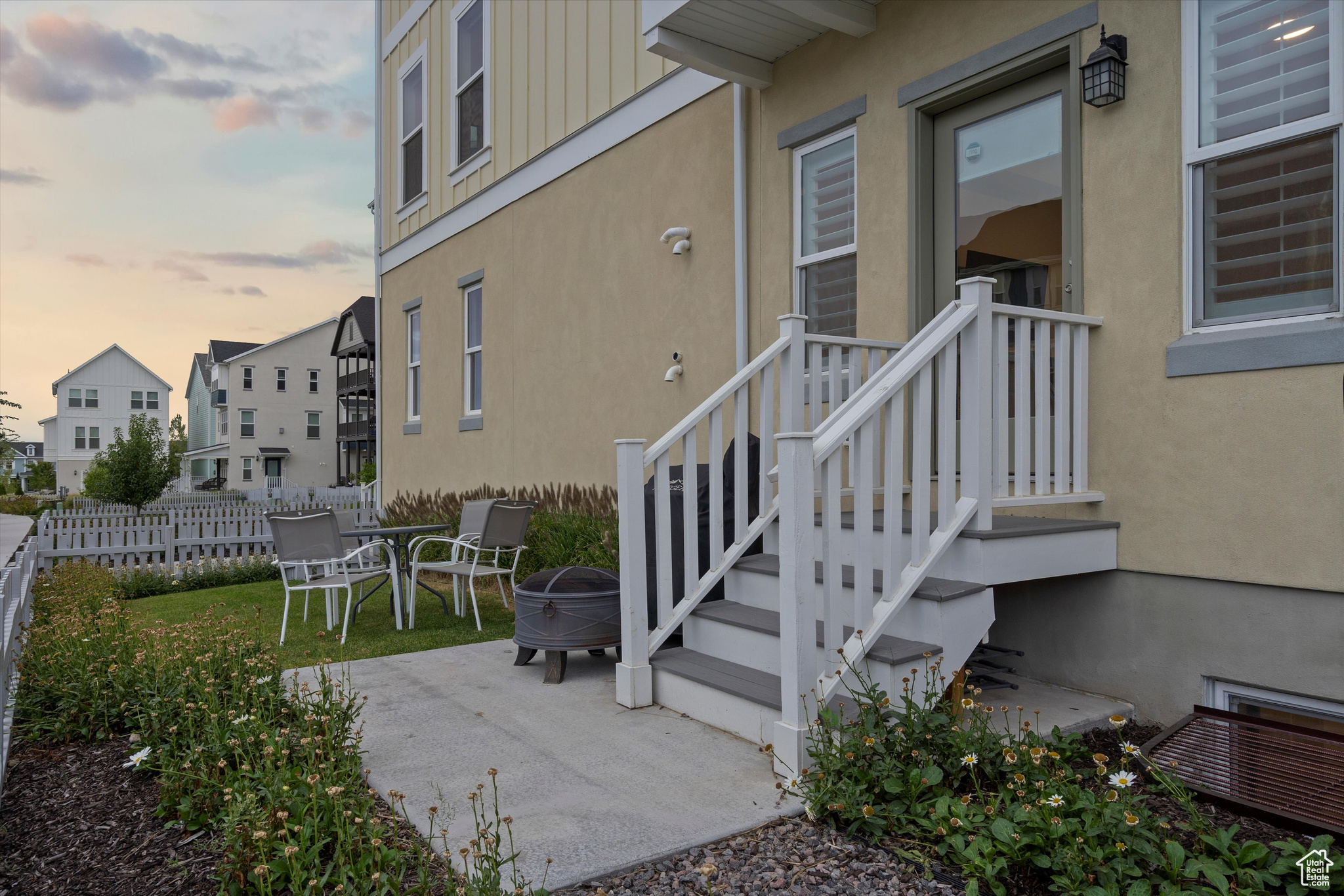 Exterior side entry at dusk featuring a patio area