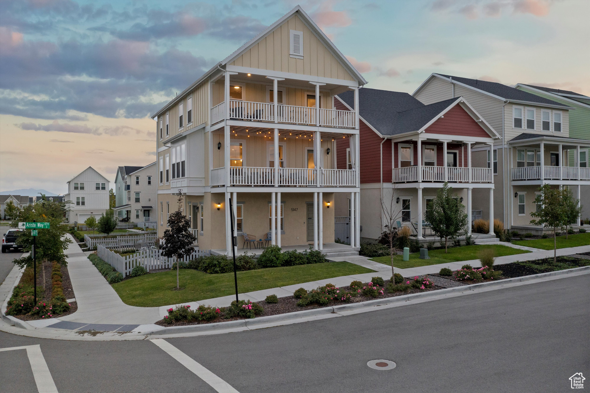 View of front of house with a balcony and a lawn