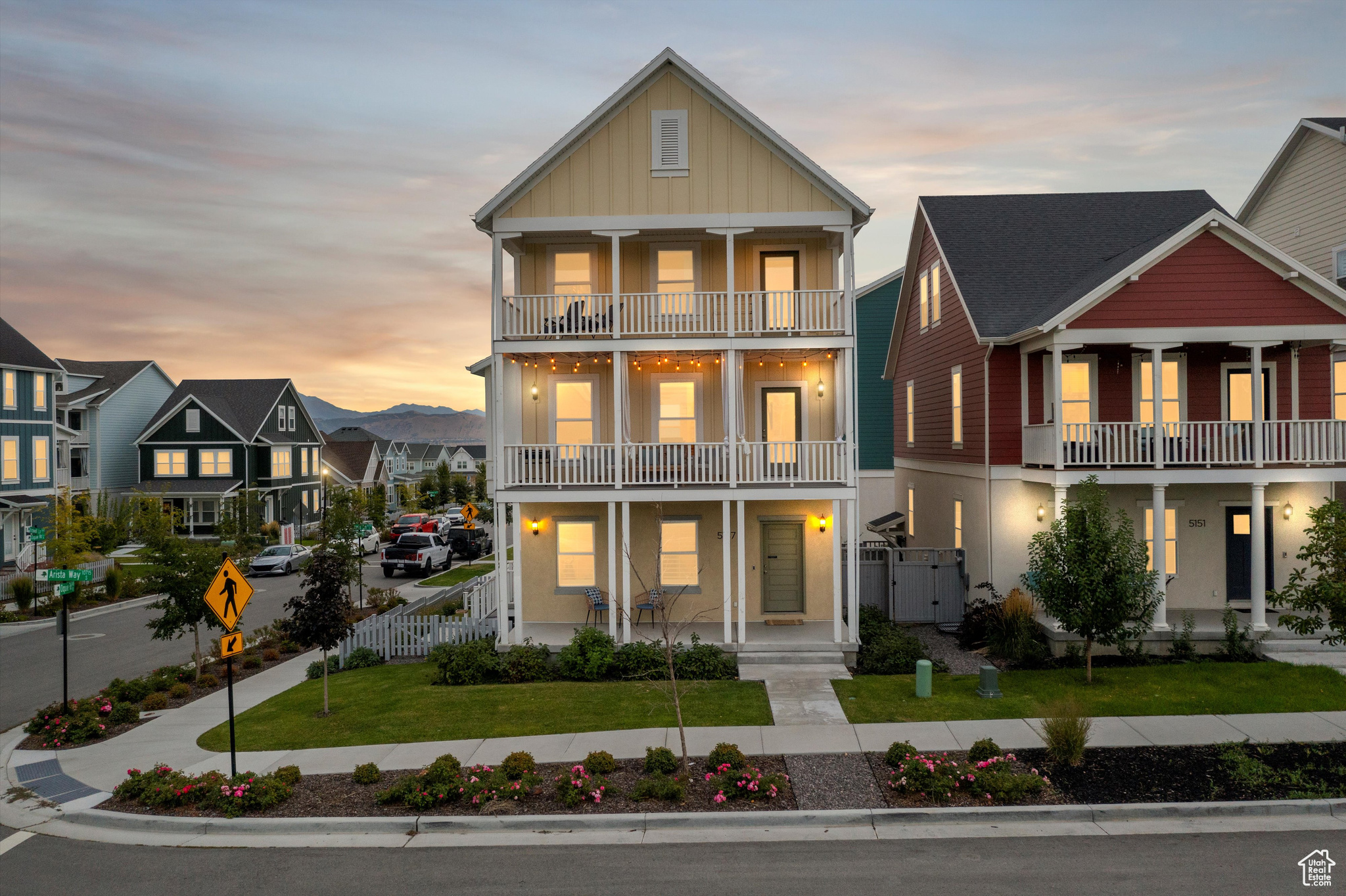 View of front of home with a lawn and a balcony