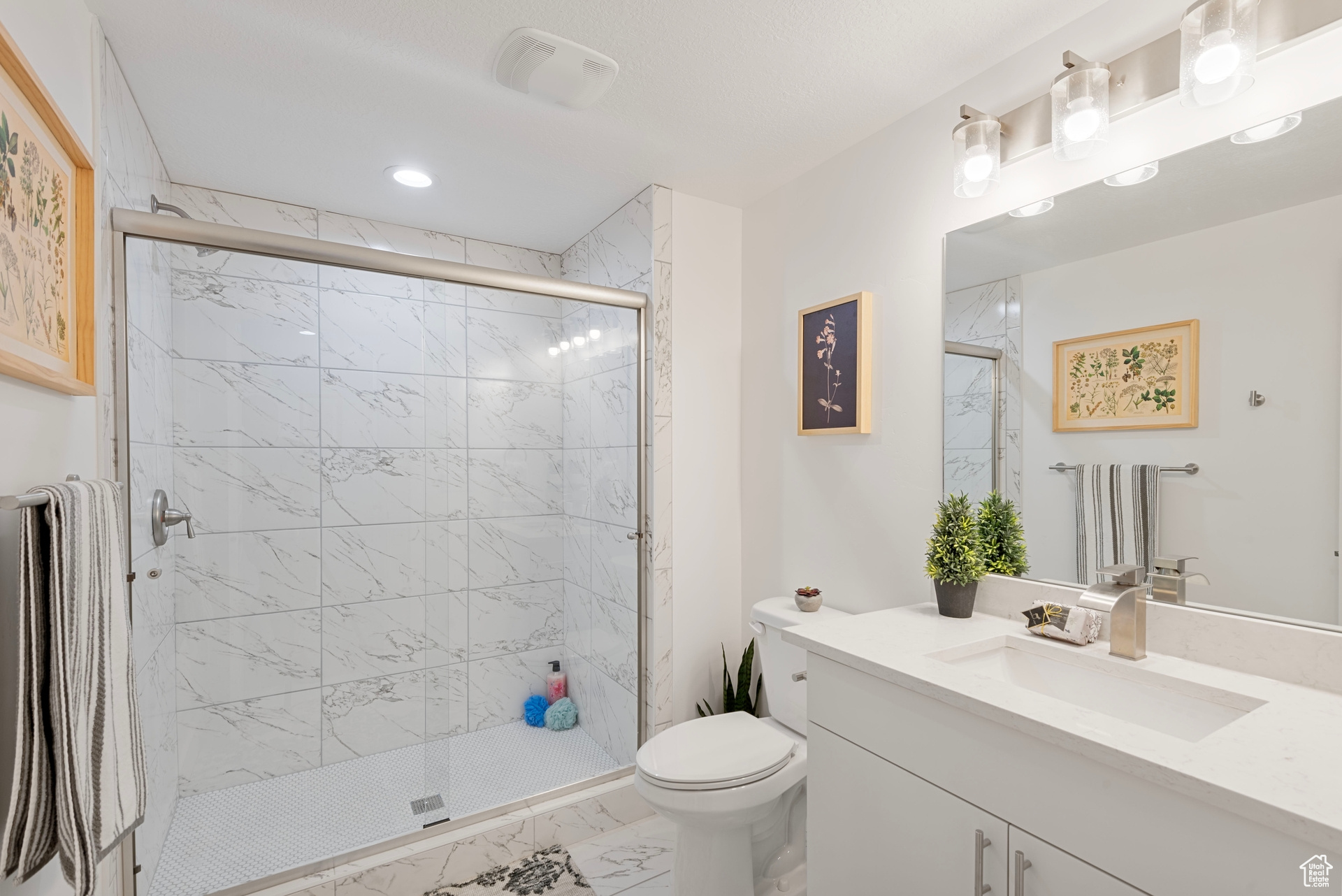 Bathroom with walk in shower, vanity, and toilet