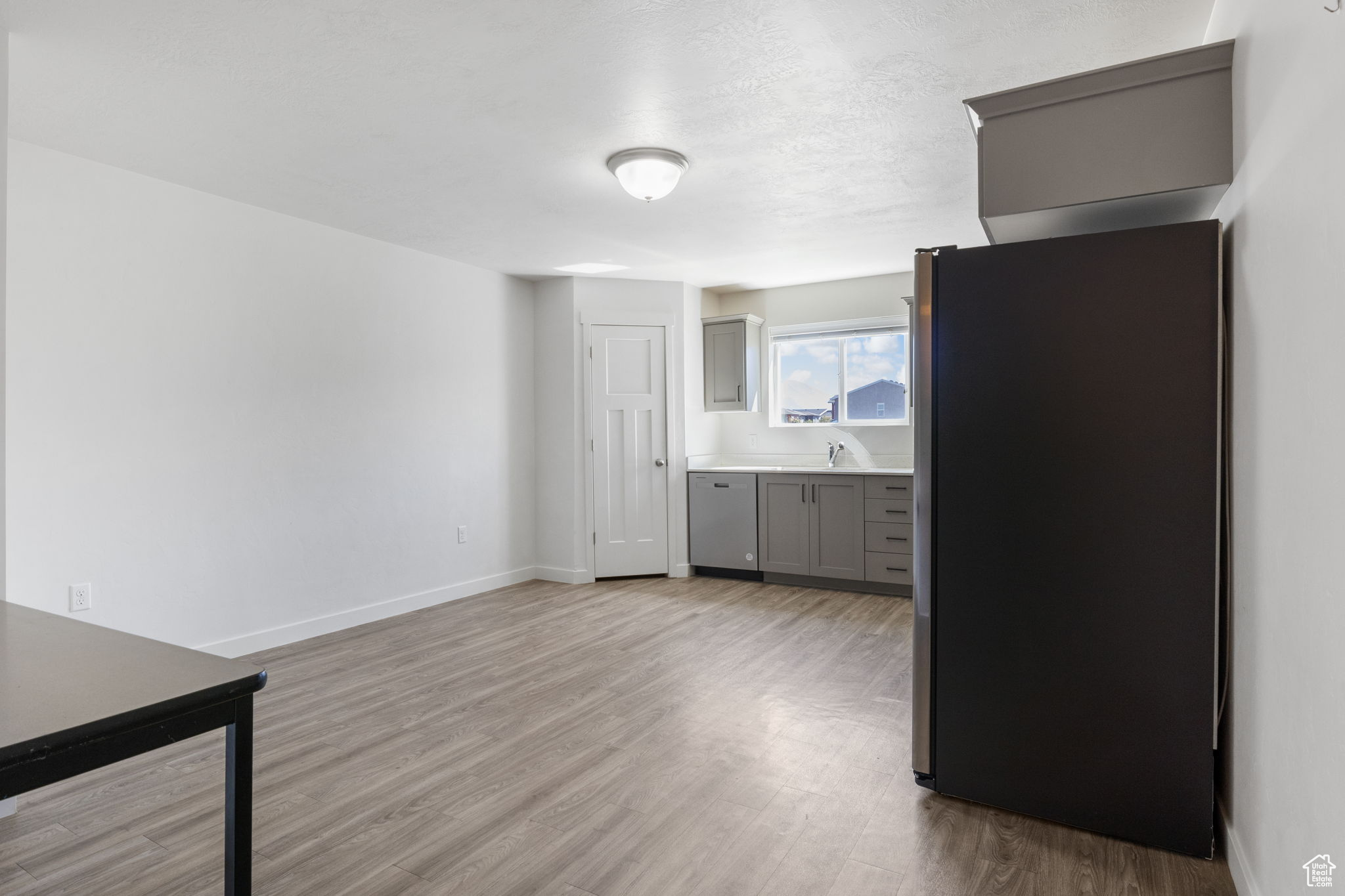 Kitchen featuring appliances with stainless steel finishes, sink, light hardwood / wood-style flooring, and gray cabinets