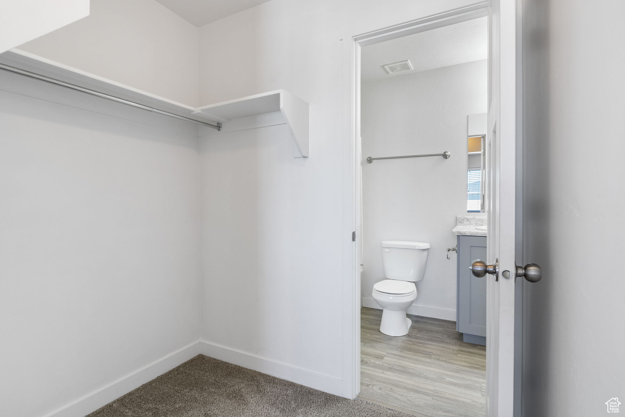 Interior space with hardwood / wood-style floors, vanity, and toilet