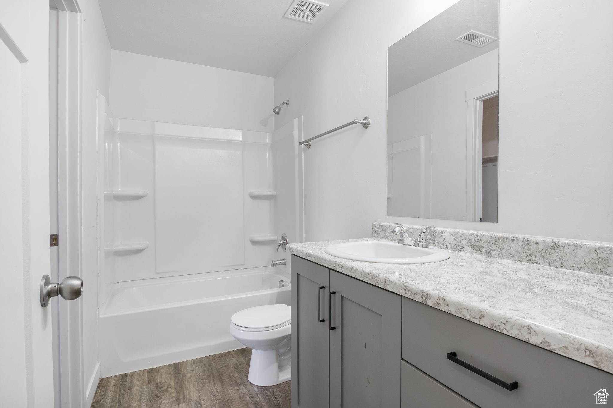 Full bathroom featuring tub / shower combination, vanity, toilet, and hardwood / wood-style flooring