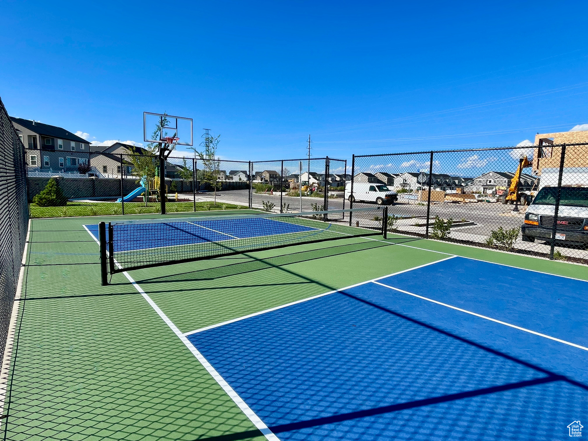 View of basketball court with tennis court and a playground