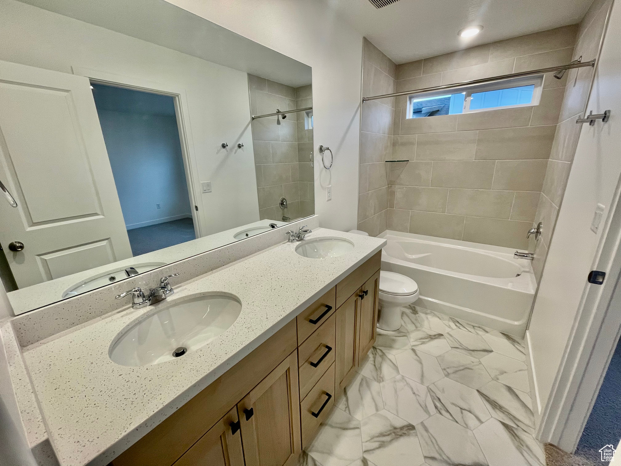 Full bathroom with vanity, toilet, and tiled shower / bath