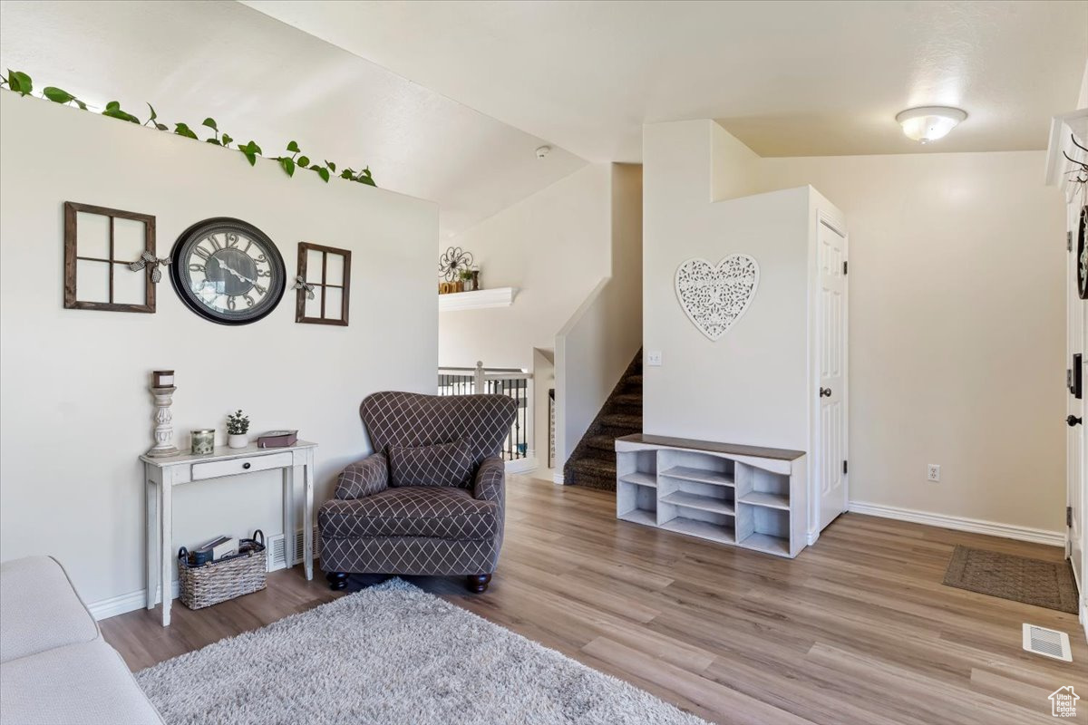 Sitting room featuring lofted ceiling and hardwood / wood-style floors