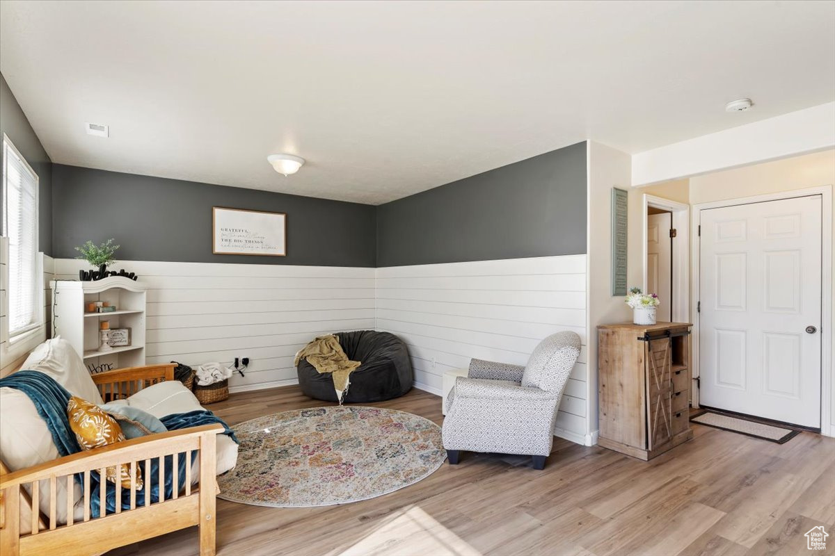 Living area featuring light hardwood / wood-style flooring and wooden walls