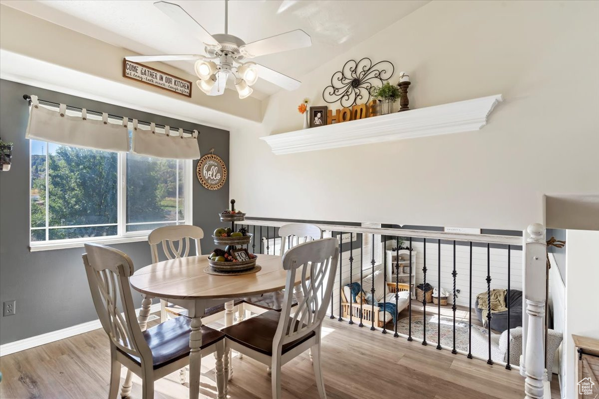 Dining area with wood-type flooring, vaulted ceiling, and ceiling fan