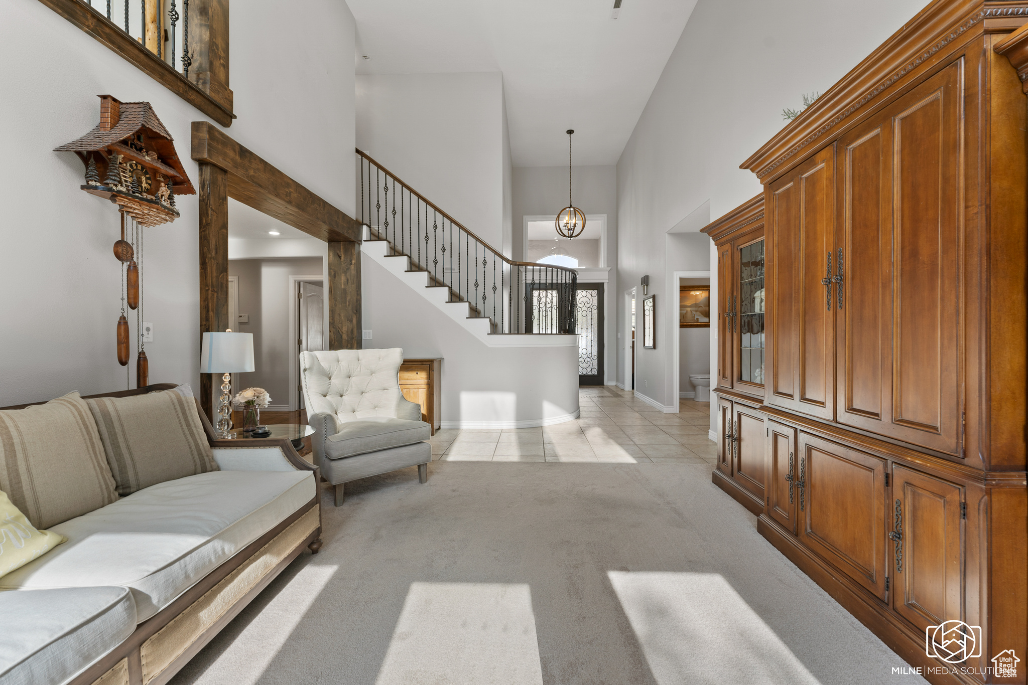 Carpeted entryway with a towering ceiling