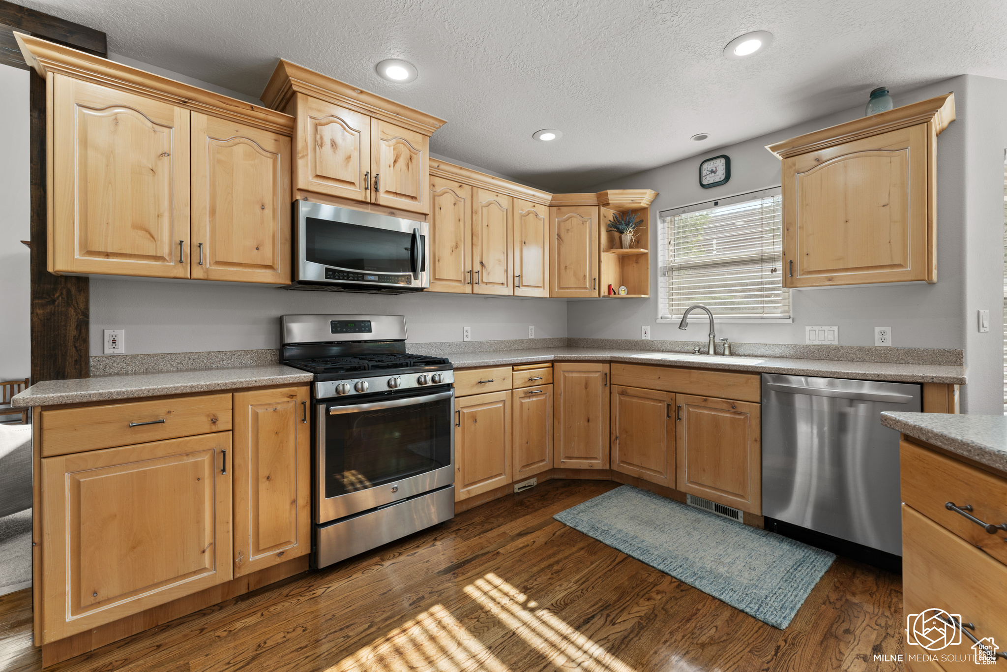 Kitchen featuring appliances with stainless steel finishes, light brown cabinetry, and sink