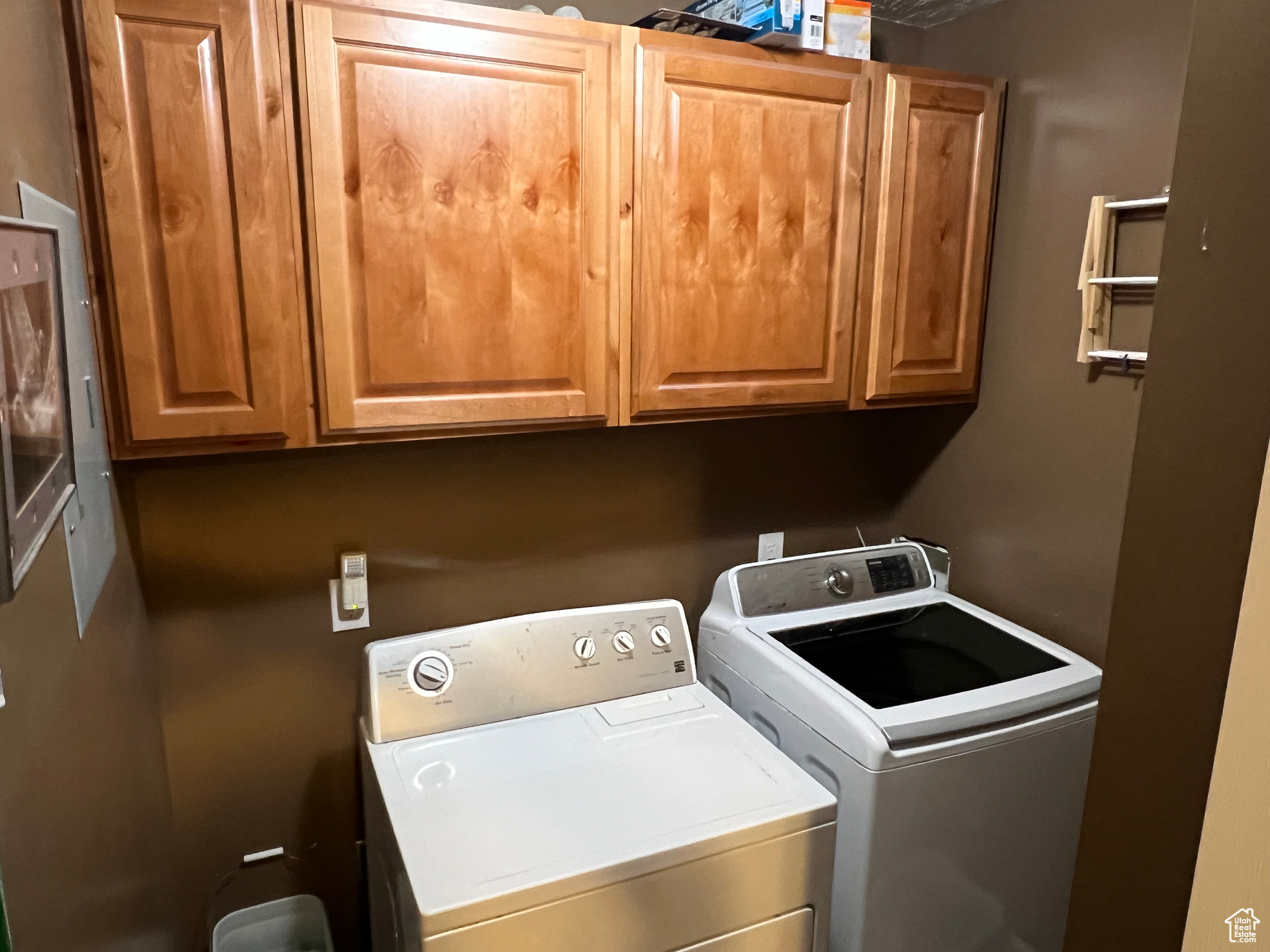 Washroom with washing machine and clothes dryer and cabinets