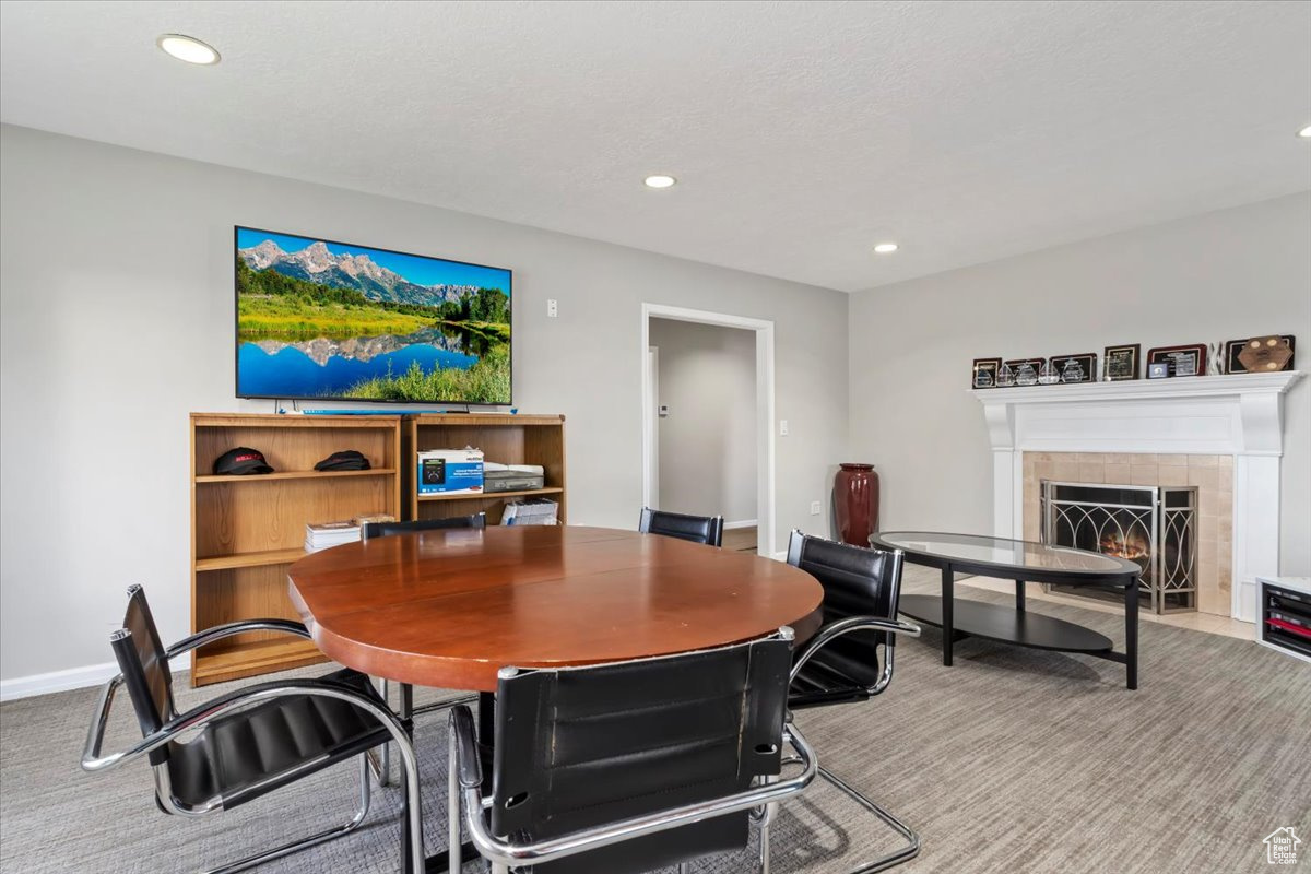 Carpeted dining area with a tiled fireplace