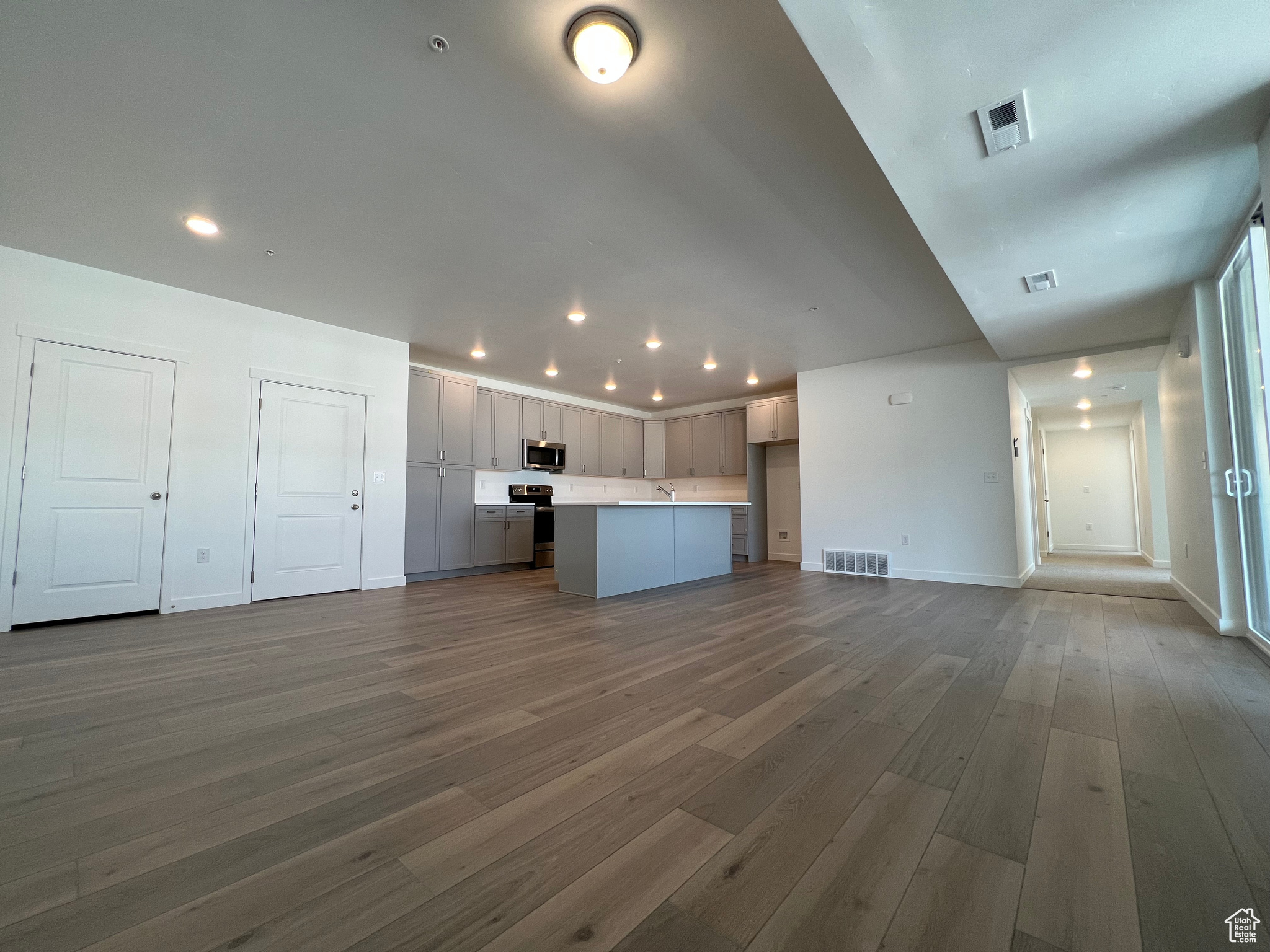 Unfurnished living room featuring wood-type flooring and sink