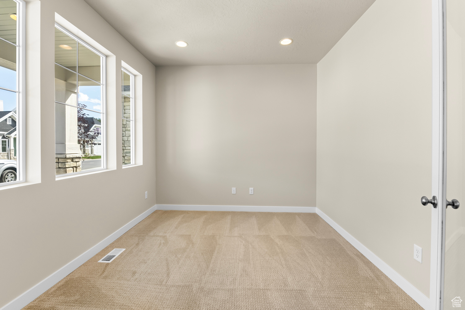 Empty room featuring light colored carpet and french doors