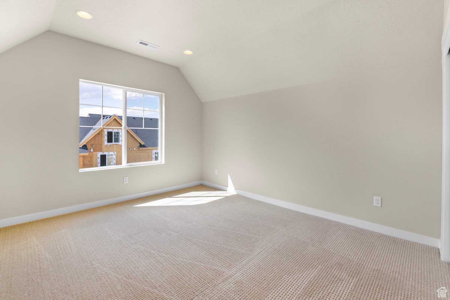 Bonus room with lofted ceiling and carpet flooring