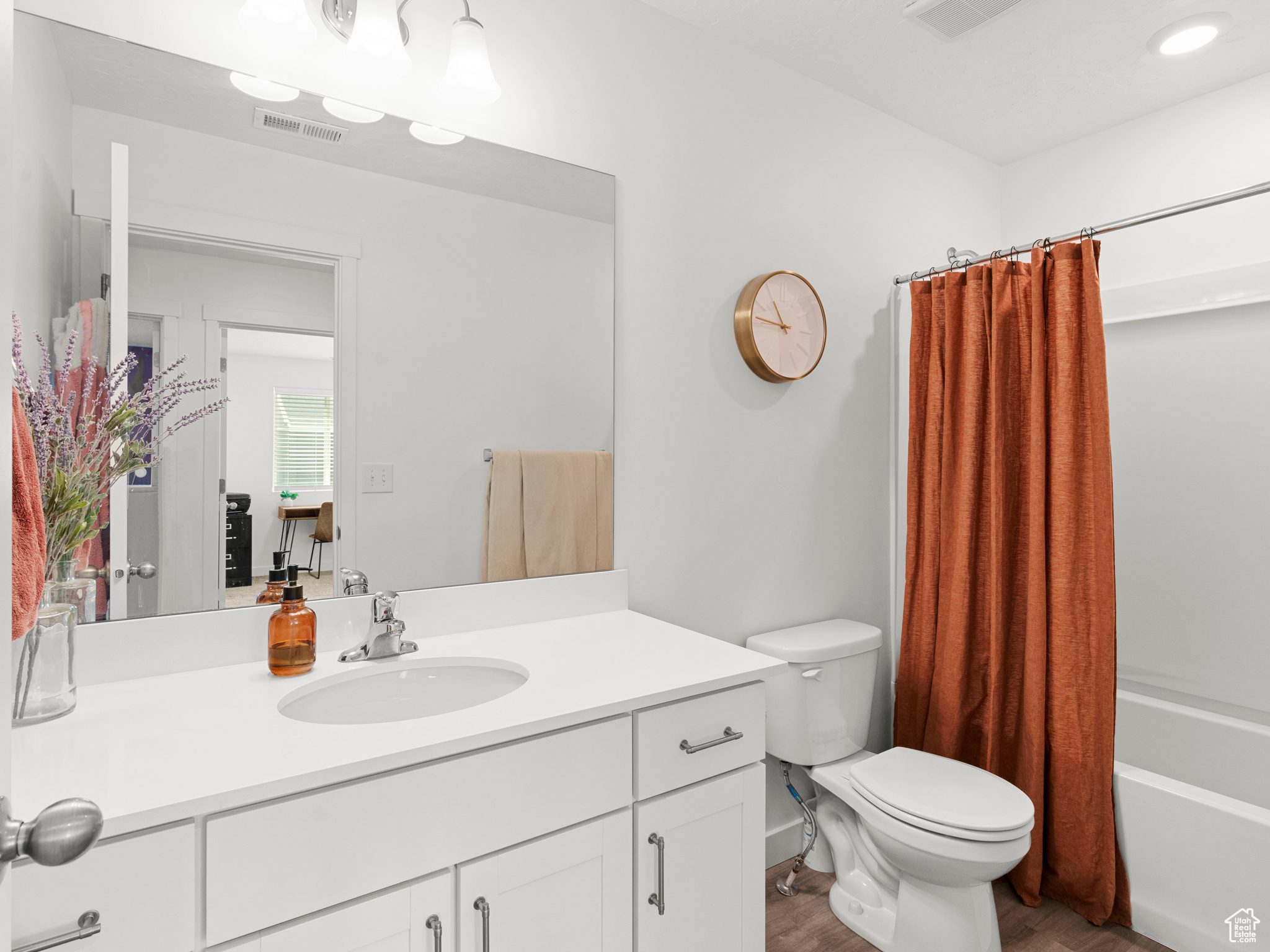 Full bathroom with shower / bath combo, vanity, toilet, and hardwood / wood-style floors