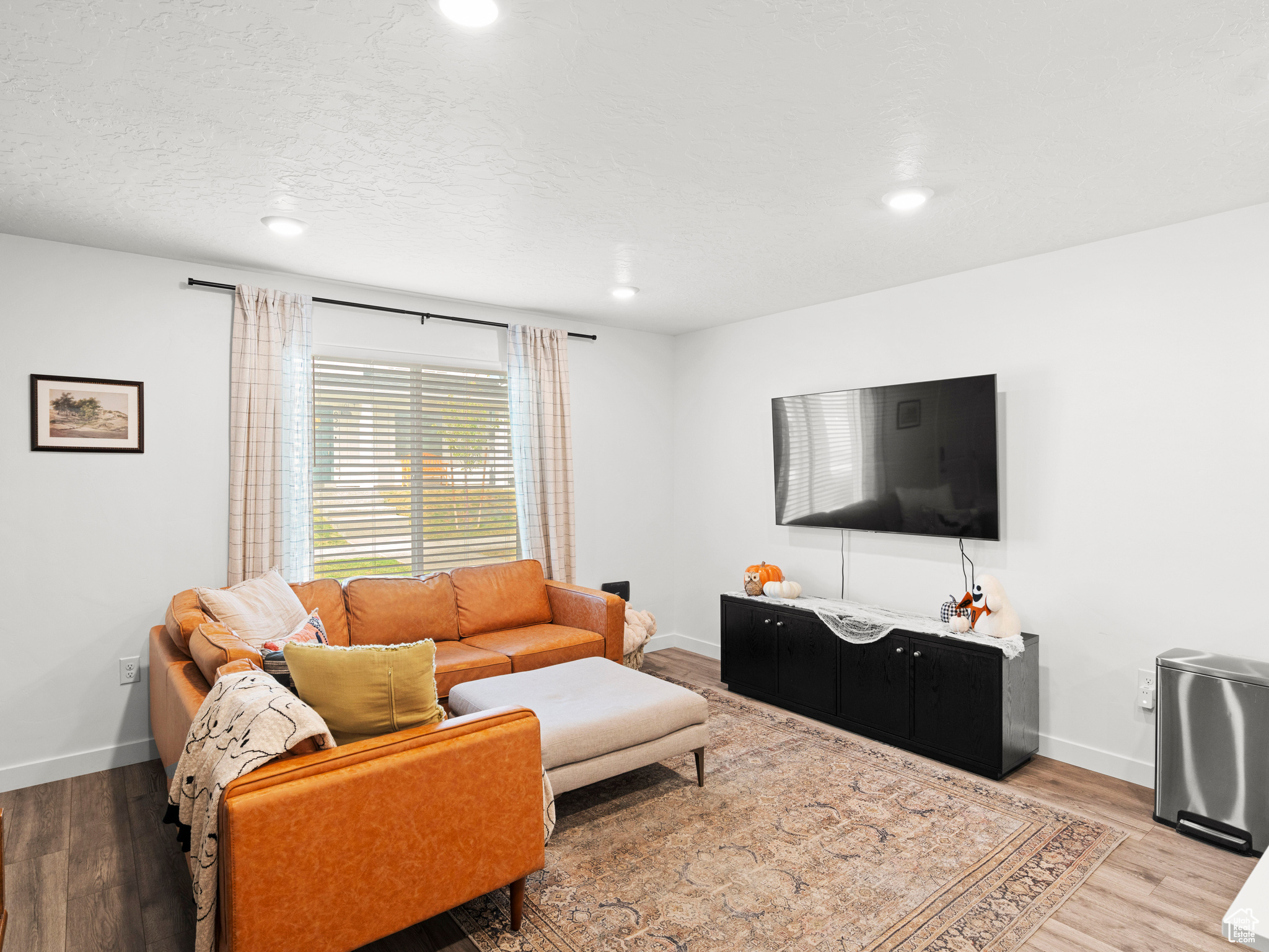 Living room with a textured ceiling and hardwood / wood-style floors