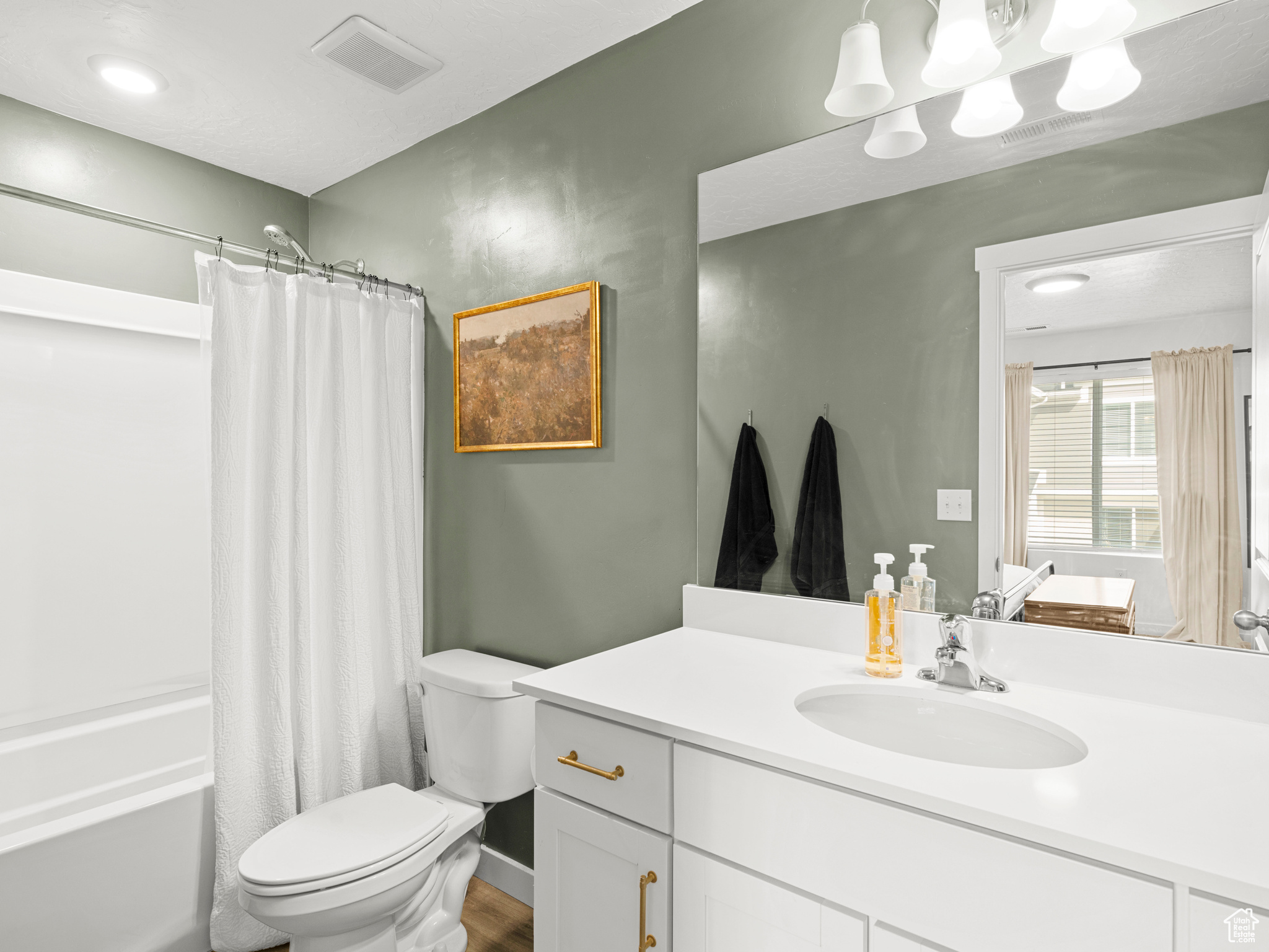 Full bathroom featuring wood-type flooring, vanity, toilet, and shower / bathtub combination with curtain