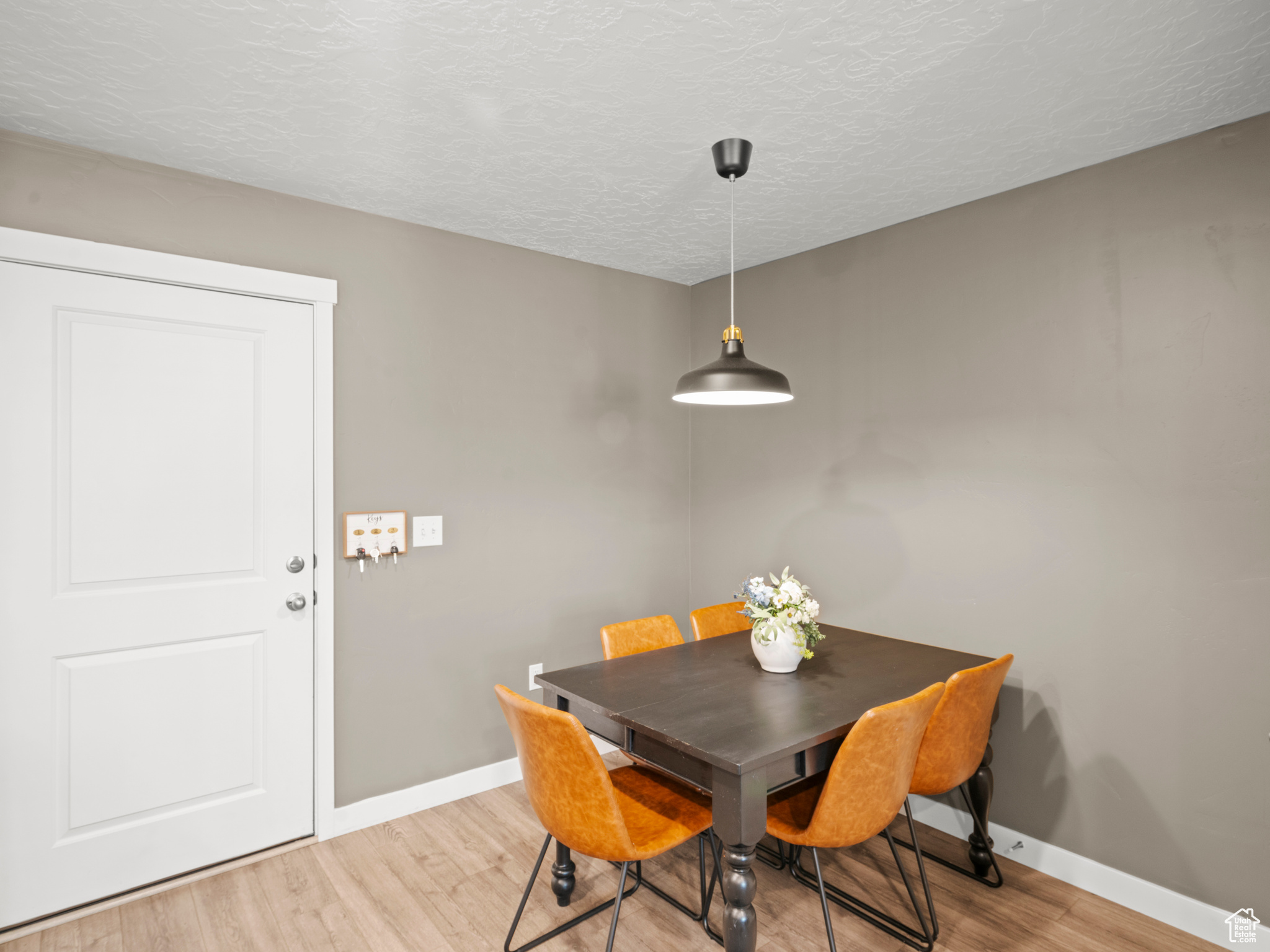 Dining area with a textured ceiling and light wood-type flooring