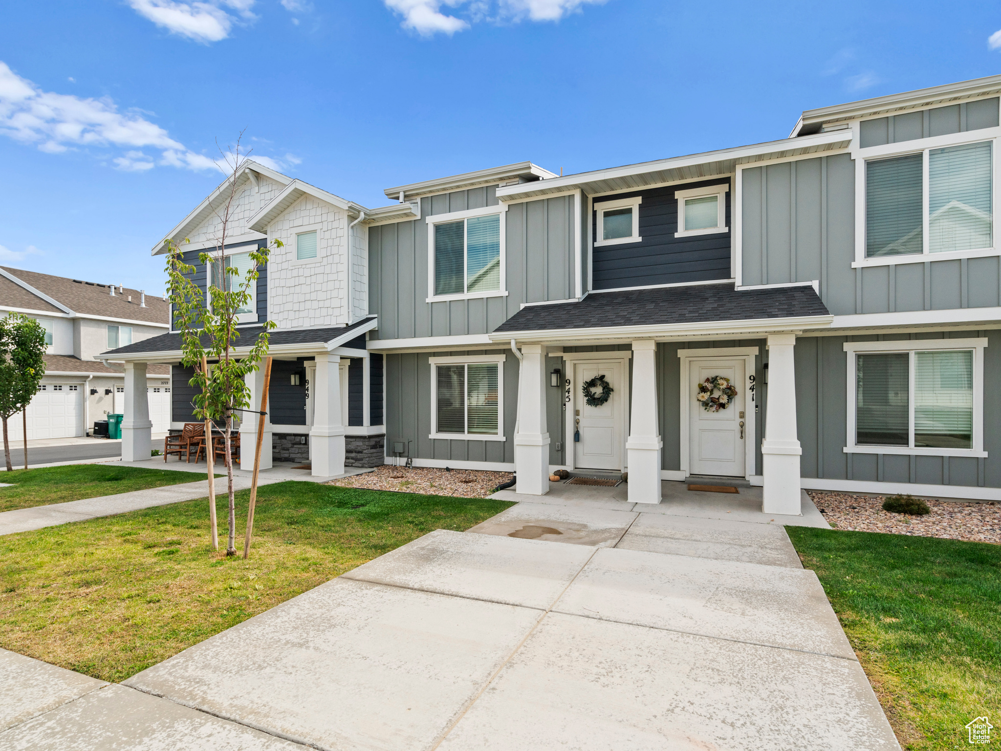 Townhome / multi-family property with a garage and a front lawn