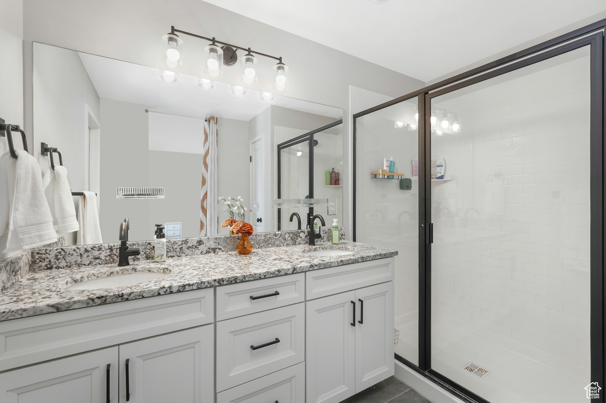 Bathroom with walk in shower, vanity, and tile patterned flooring