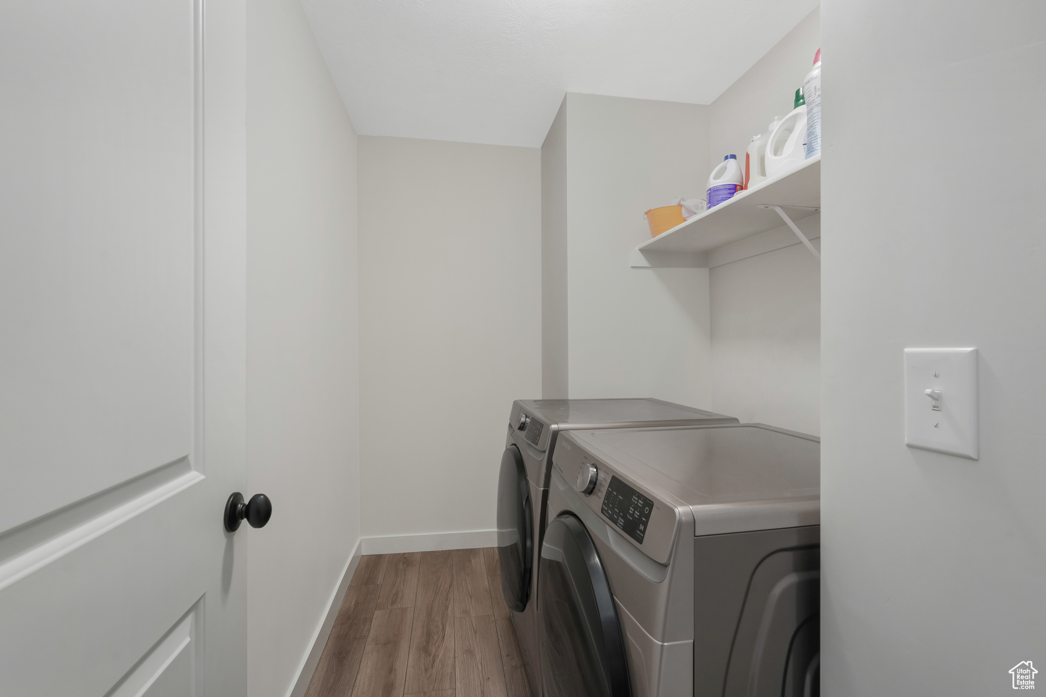 Washroom with light wood-type flooring and separate washer and dryer