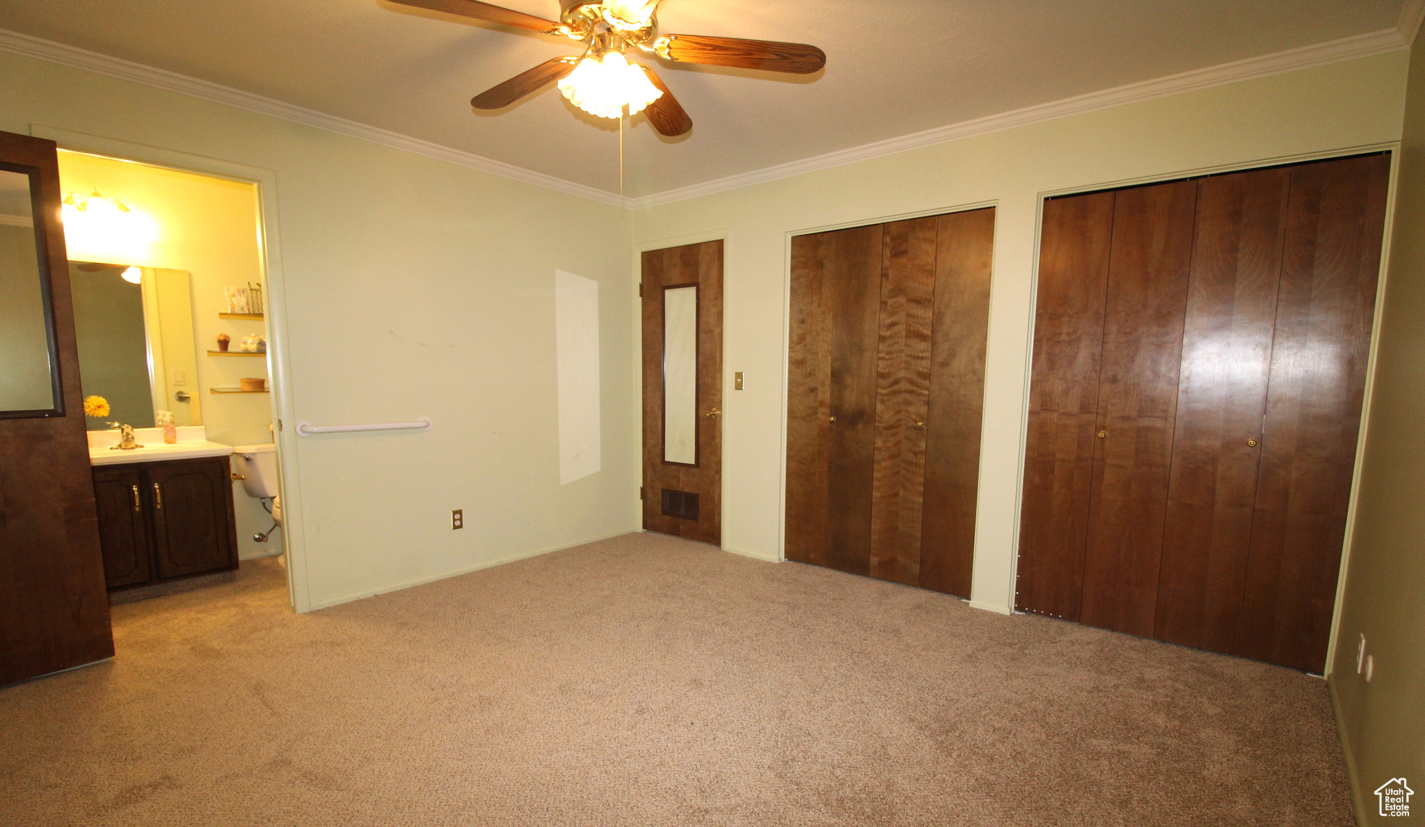 Primary bedroom featuring ornamental molding, and ceiling fan