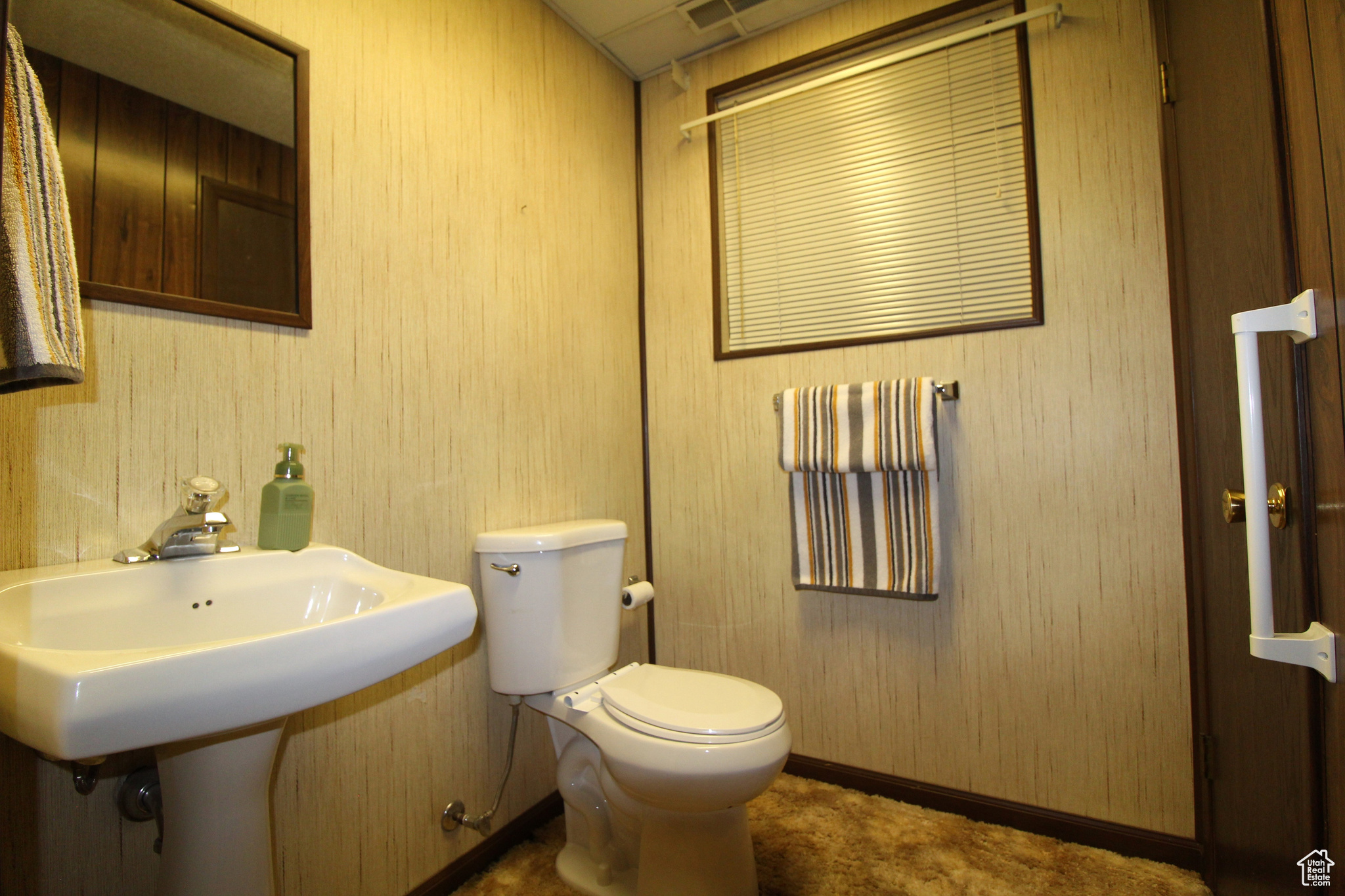 Bathroom featuring wood walls and toilet