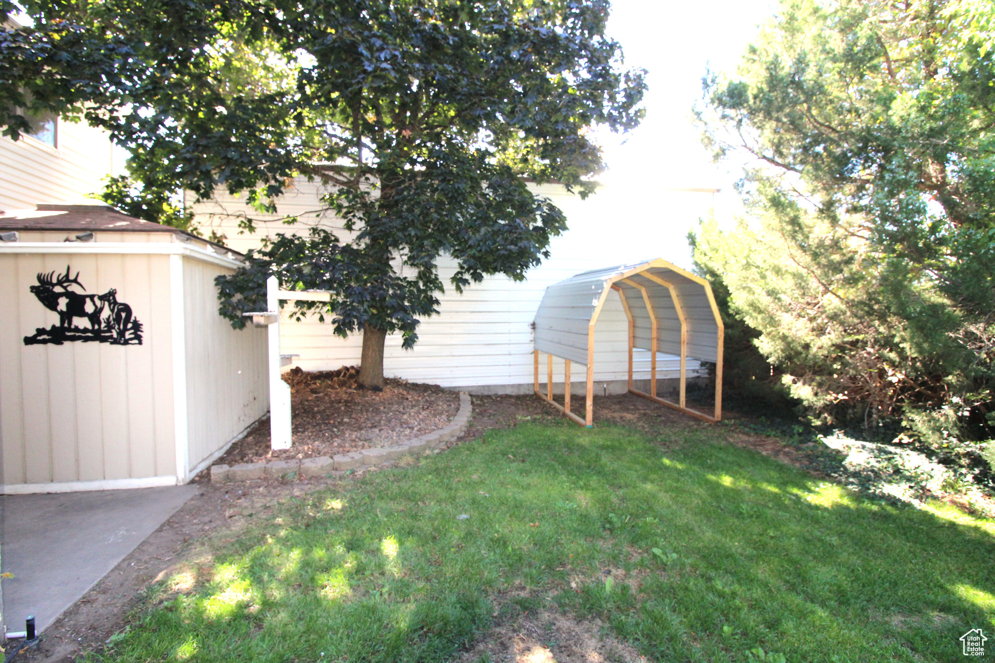 View of yard featuring a storage shed and covered area