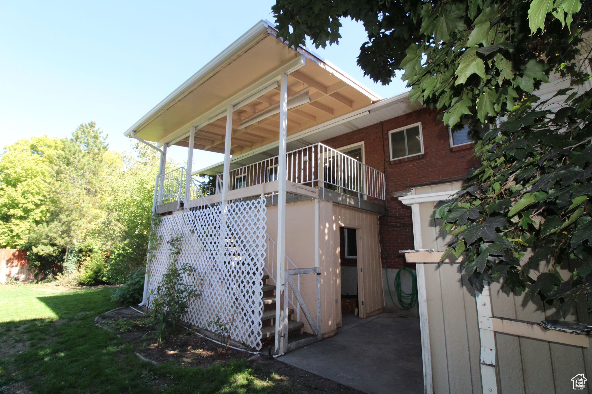 Rear view of property with a covered deck and a yard