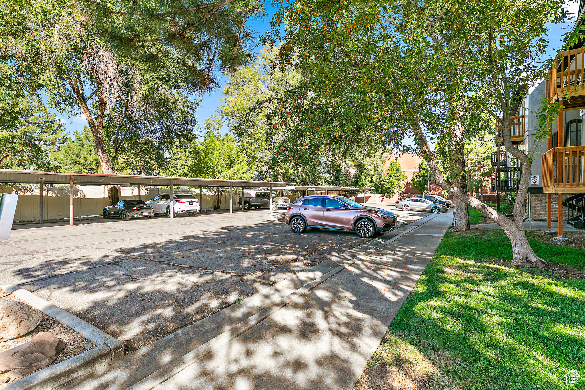 View of parking featuring a lawn and a carport