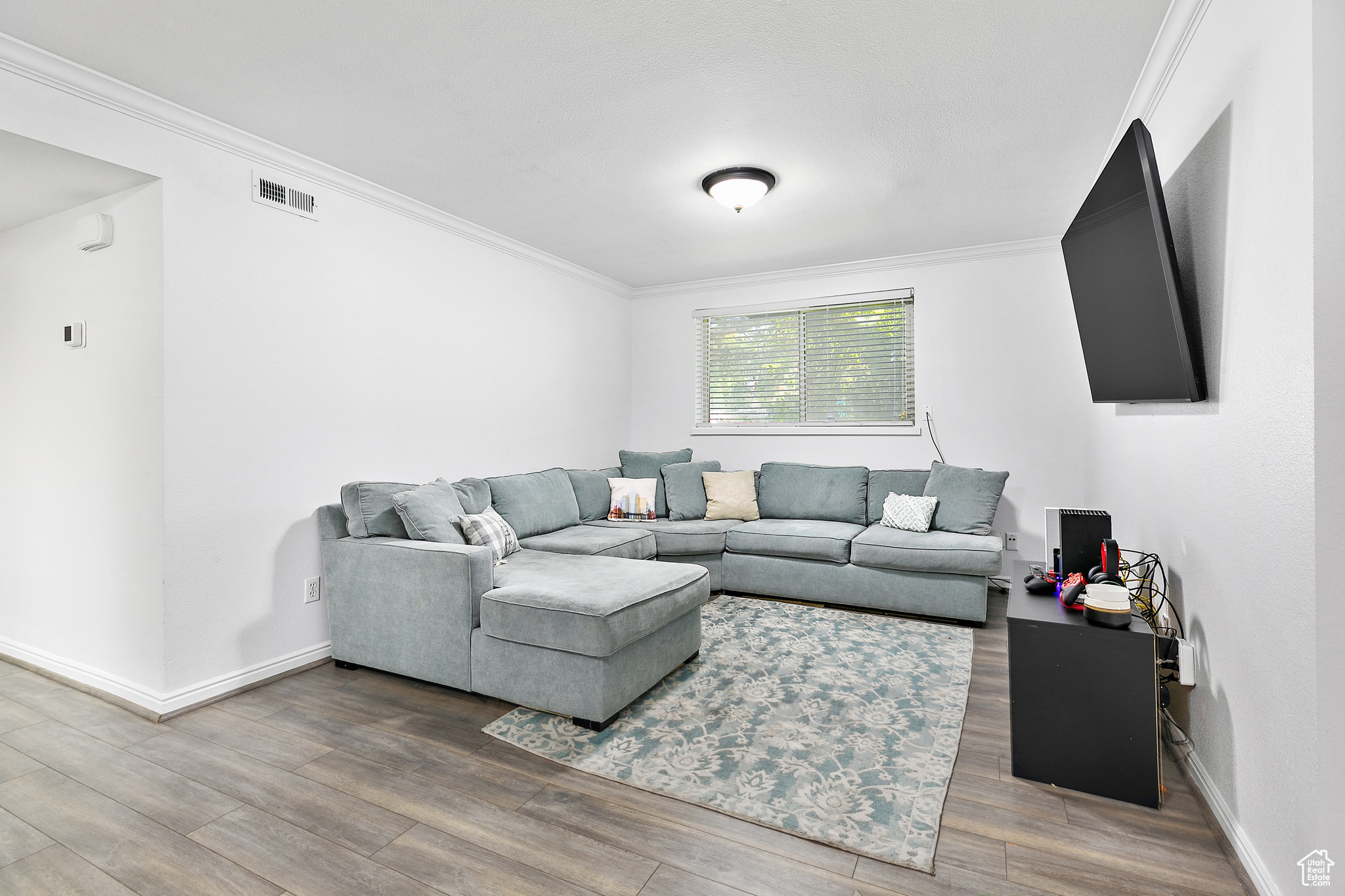 Living room featuring ornamental molding and light beautiful LVP flooring