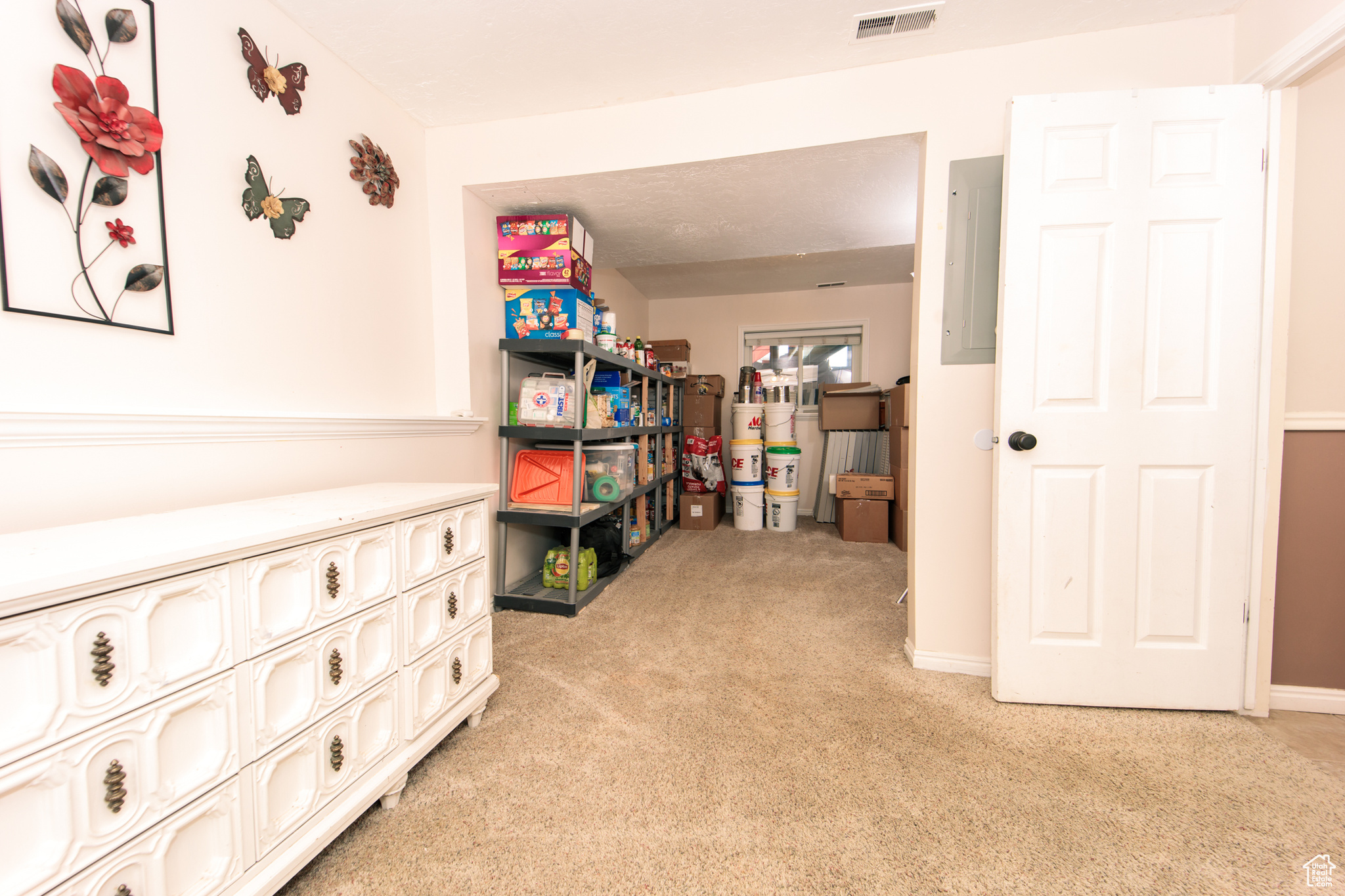 Interior space featuring electric panel and light colored carpet