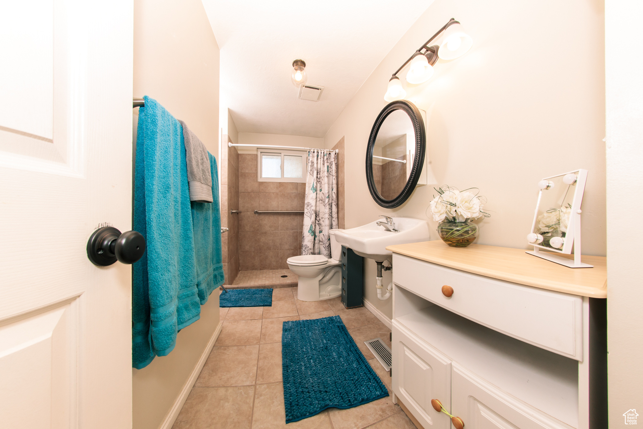 Bathroom with walk in shower, sink, tile patterned flooring, and toilet