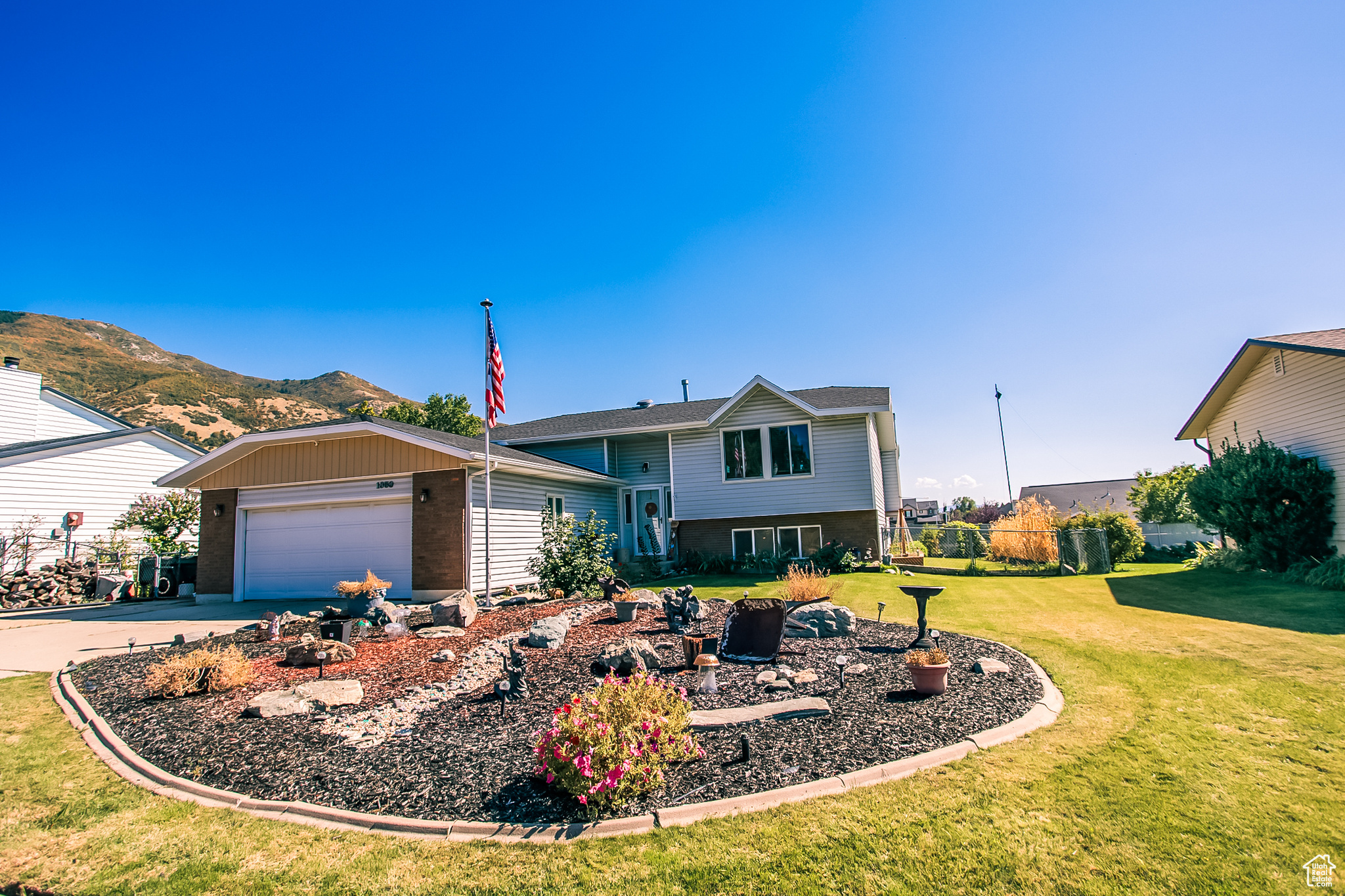 View of front of house with a garage, a mountain view, and a front yard