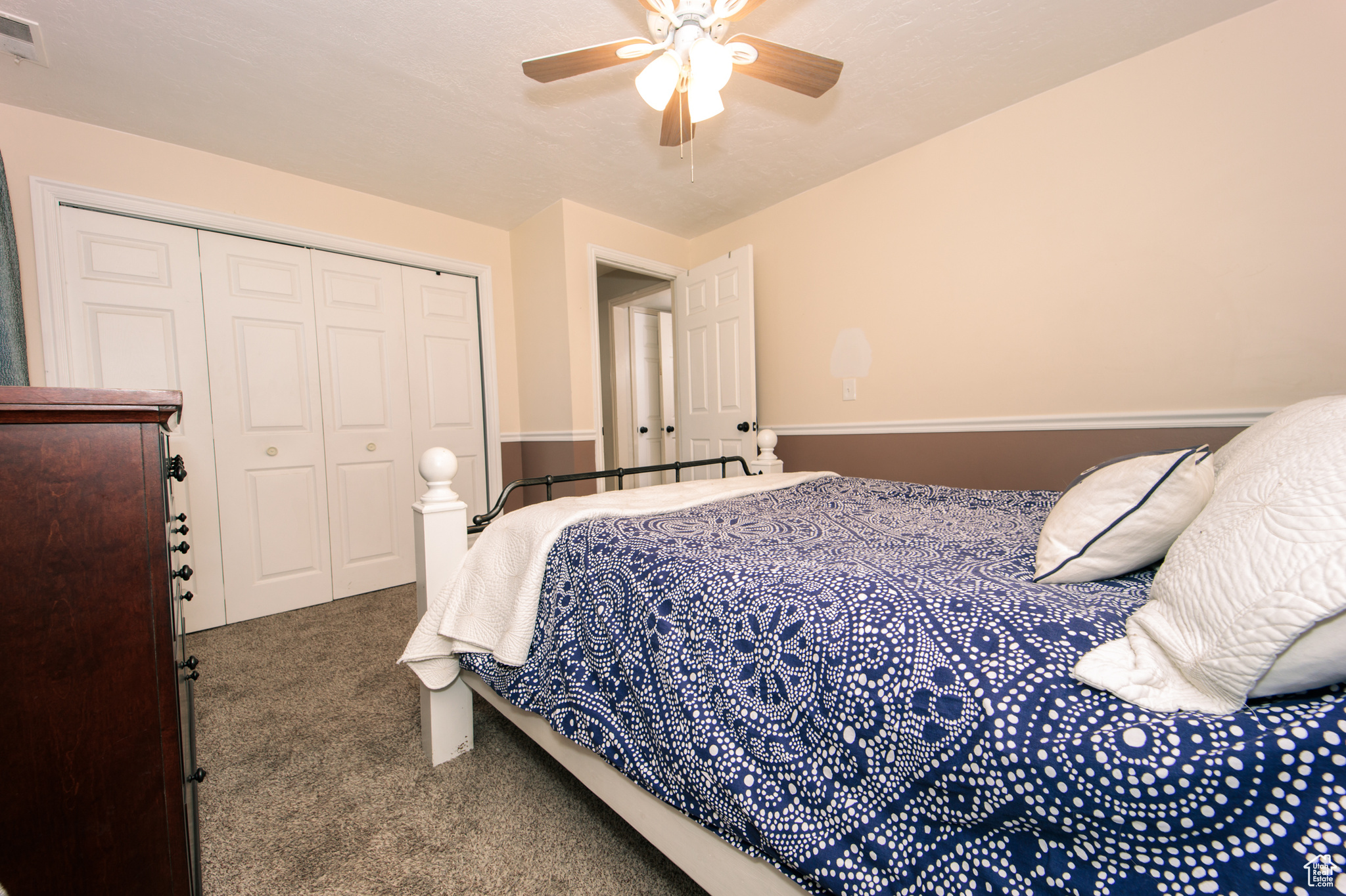 Carpeted bedroom featuring a closet and ceiling fan