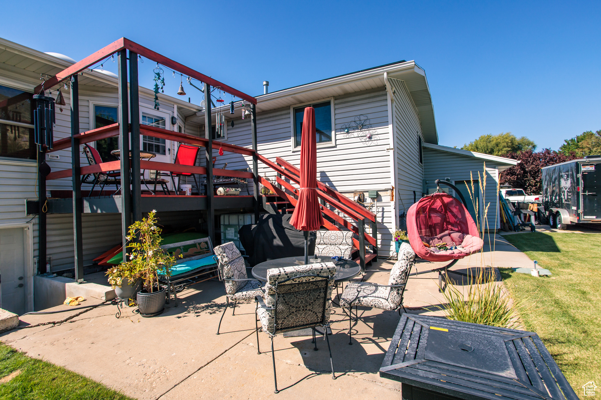 Rear view of property with a wooden deck, a patio area, and a yard