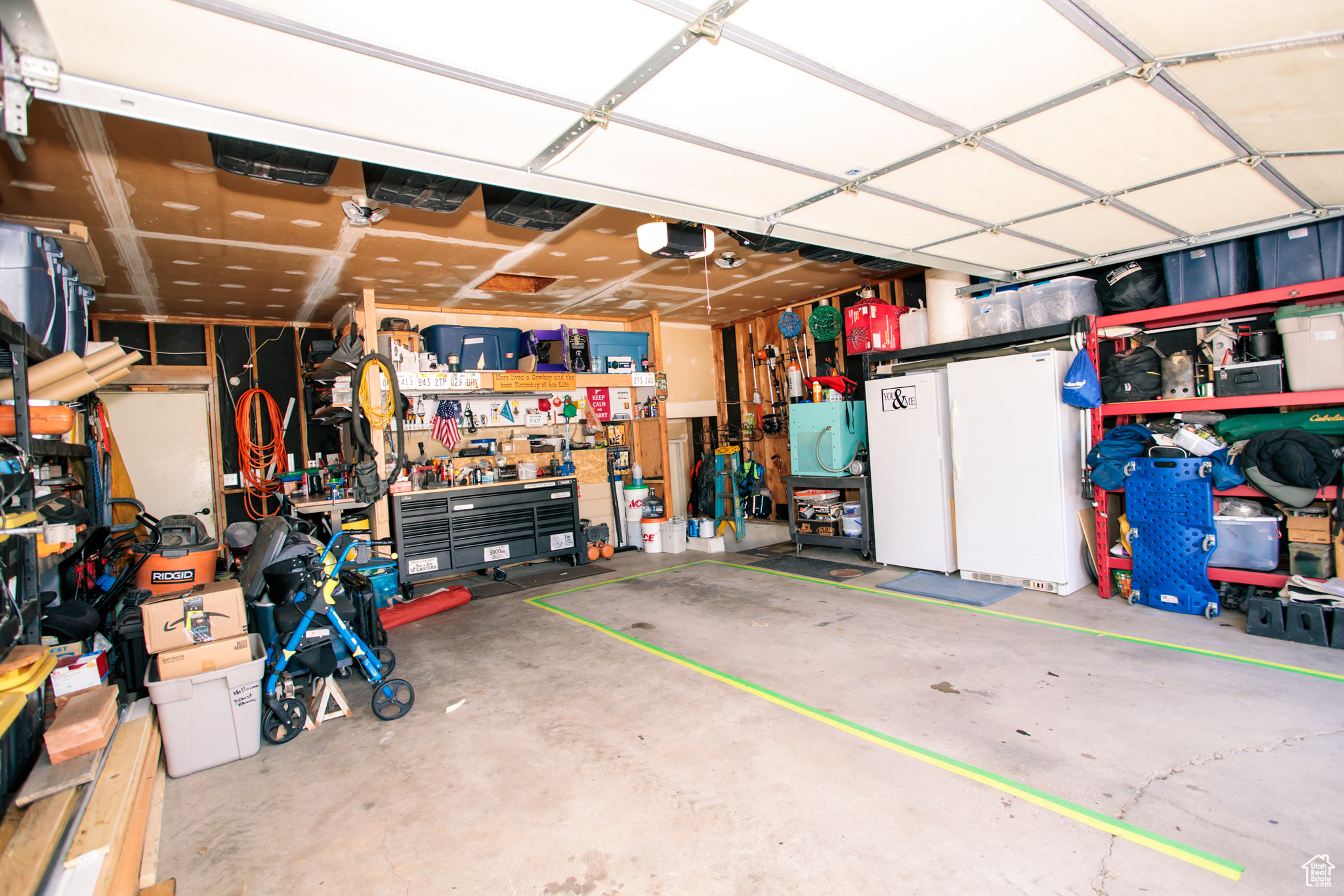 Garage featuring a garage door opener and a workshop area