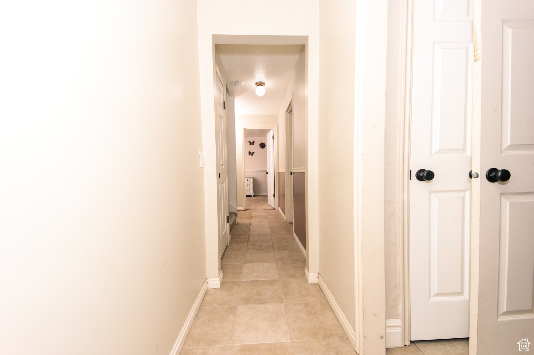 Corridor featuring light tile patterned floors