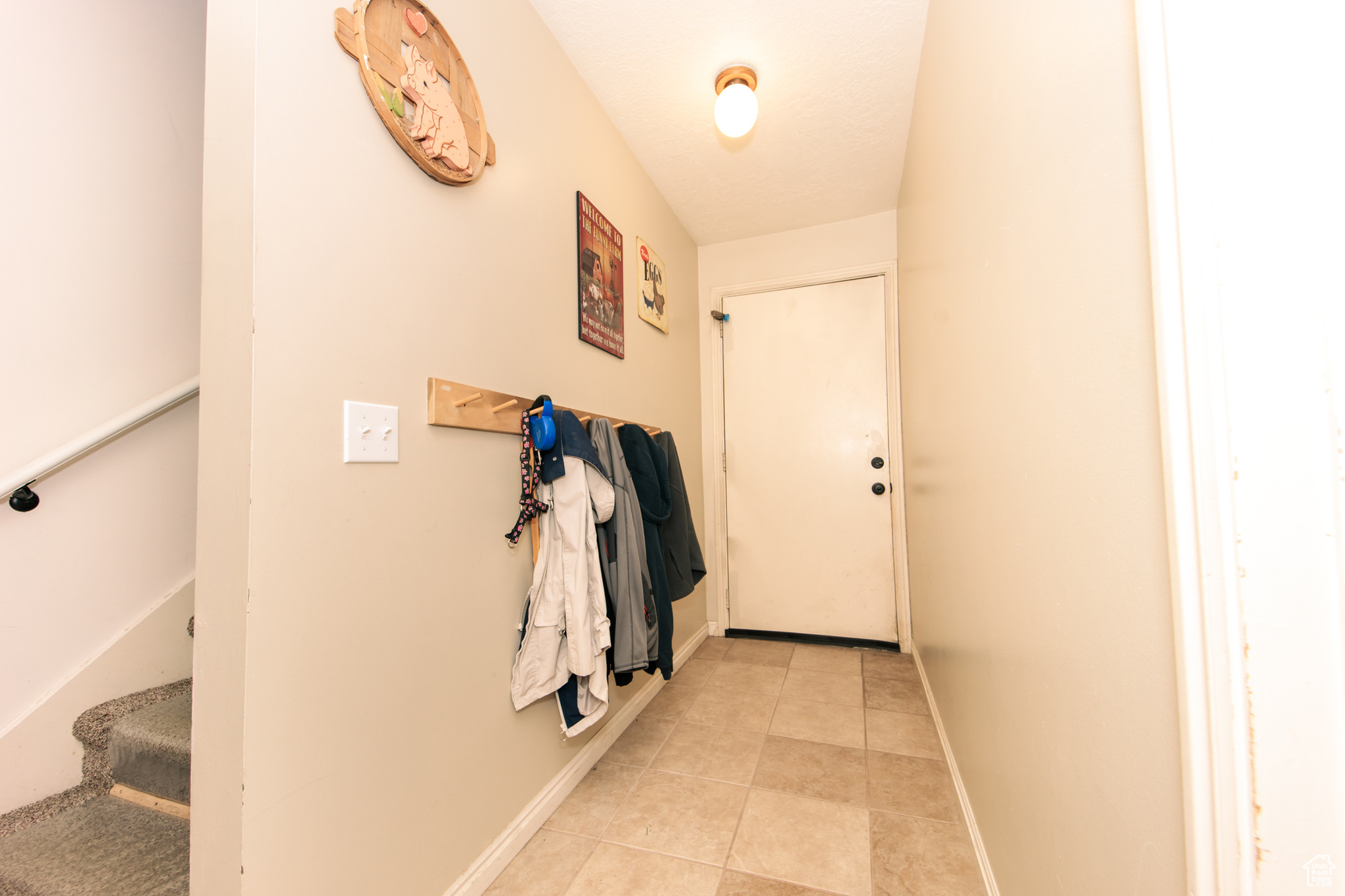 Doorway with light tile patterned flooring