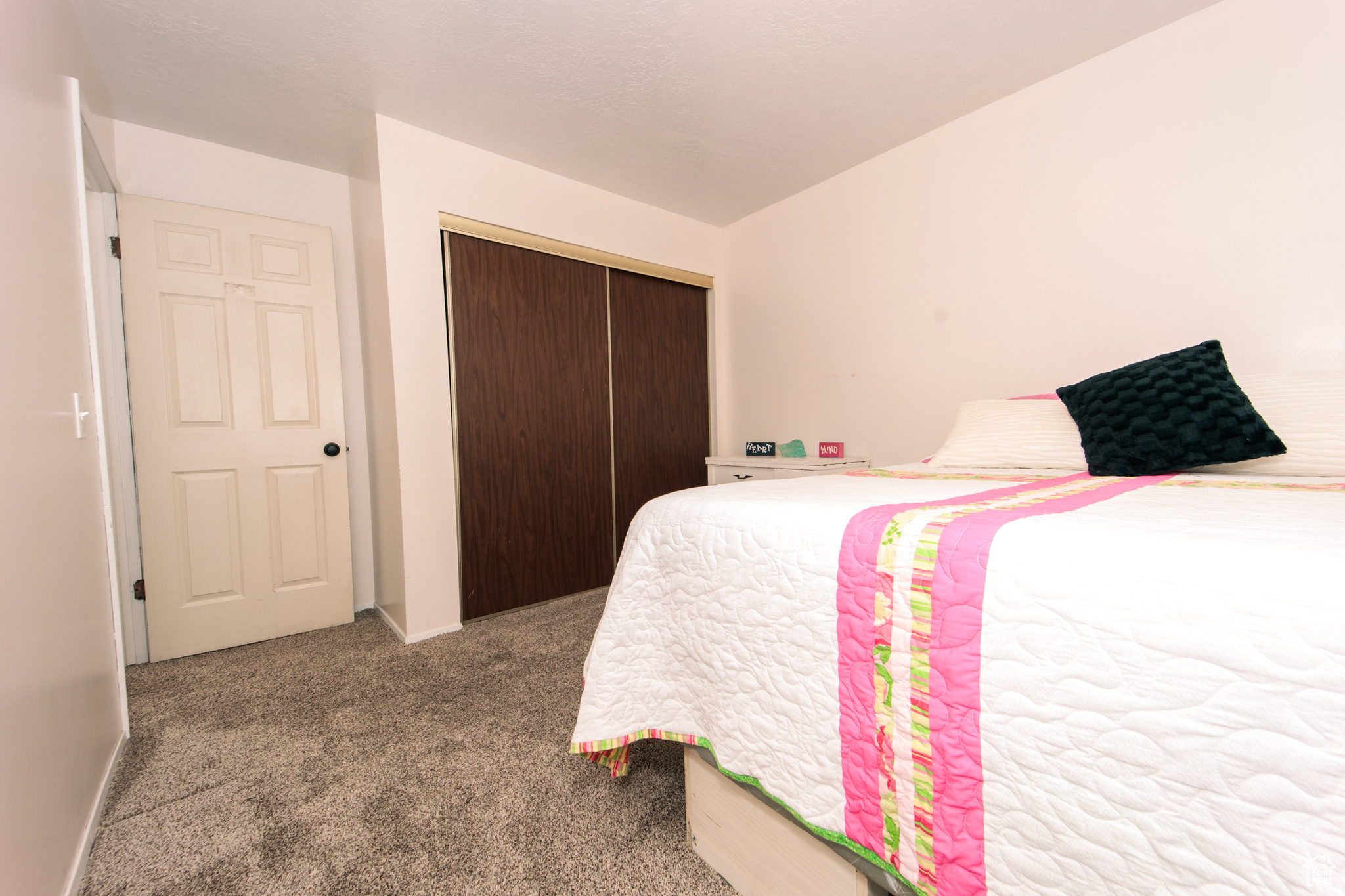 Bedroom featuring light carpet and a closet