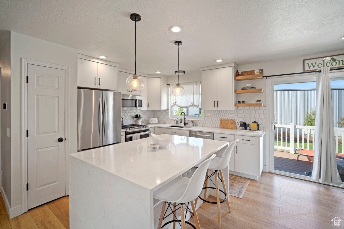 New Kitchen With Water Fall Island, Modern Flooring, and Custom Backsplash and Shelving