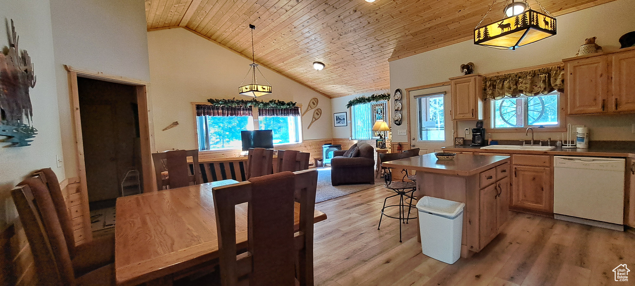 Kitchen featuring wood ceiling, dishwasher, sink, a kitchen island, and decorative light fixtures