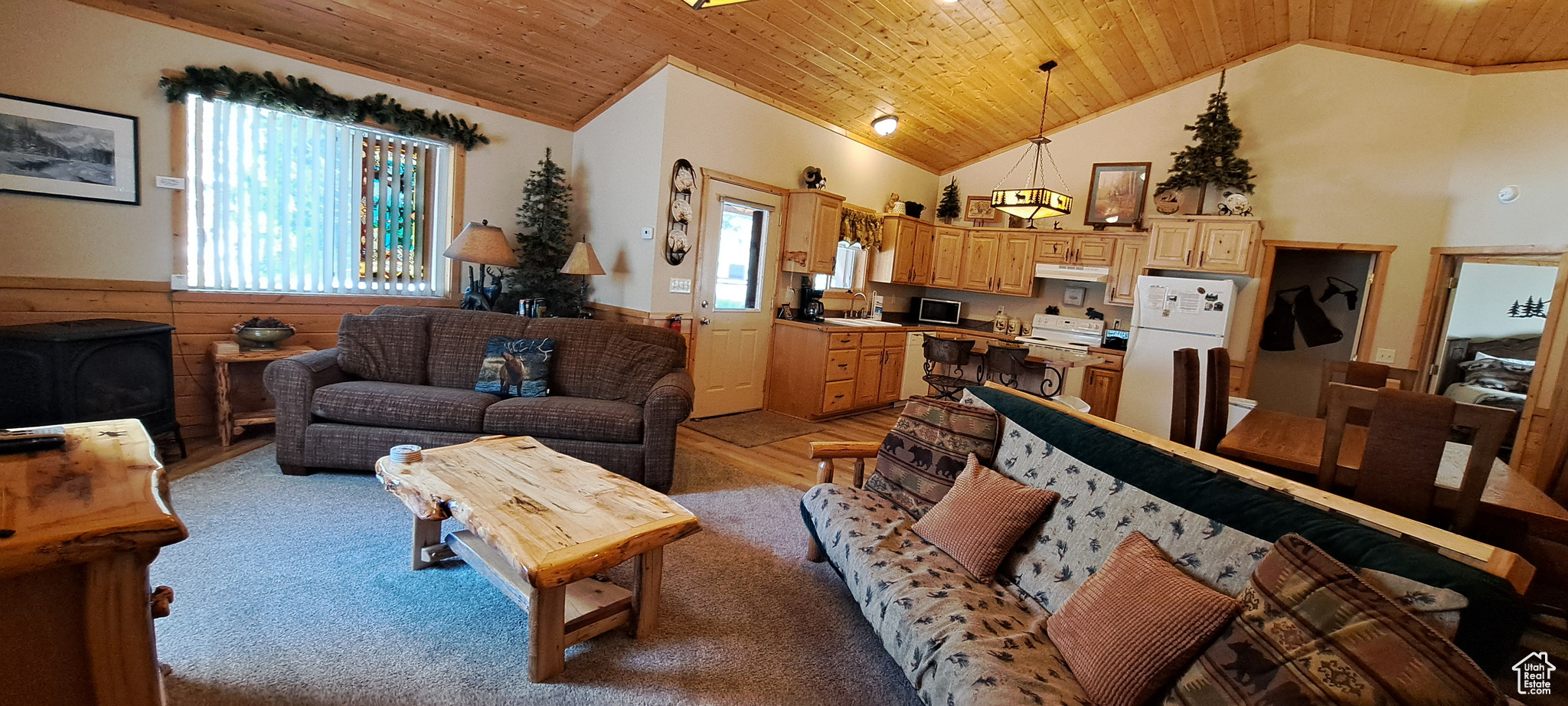 Living room with wood ceiling, wood walls, hardwood / wood-style flooring, and sink