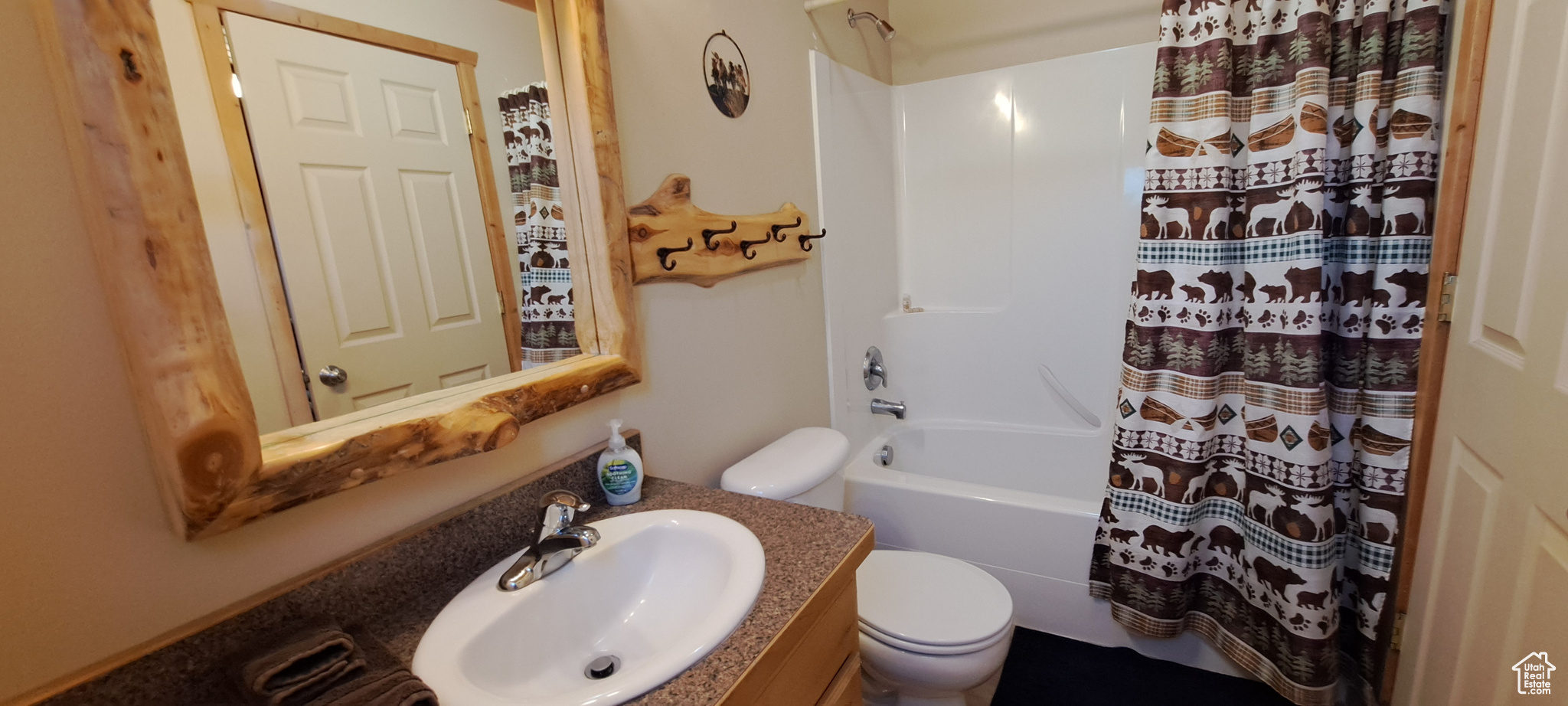 Full bathroom with vanity, shower / bath combo with shower curtain, and toilet