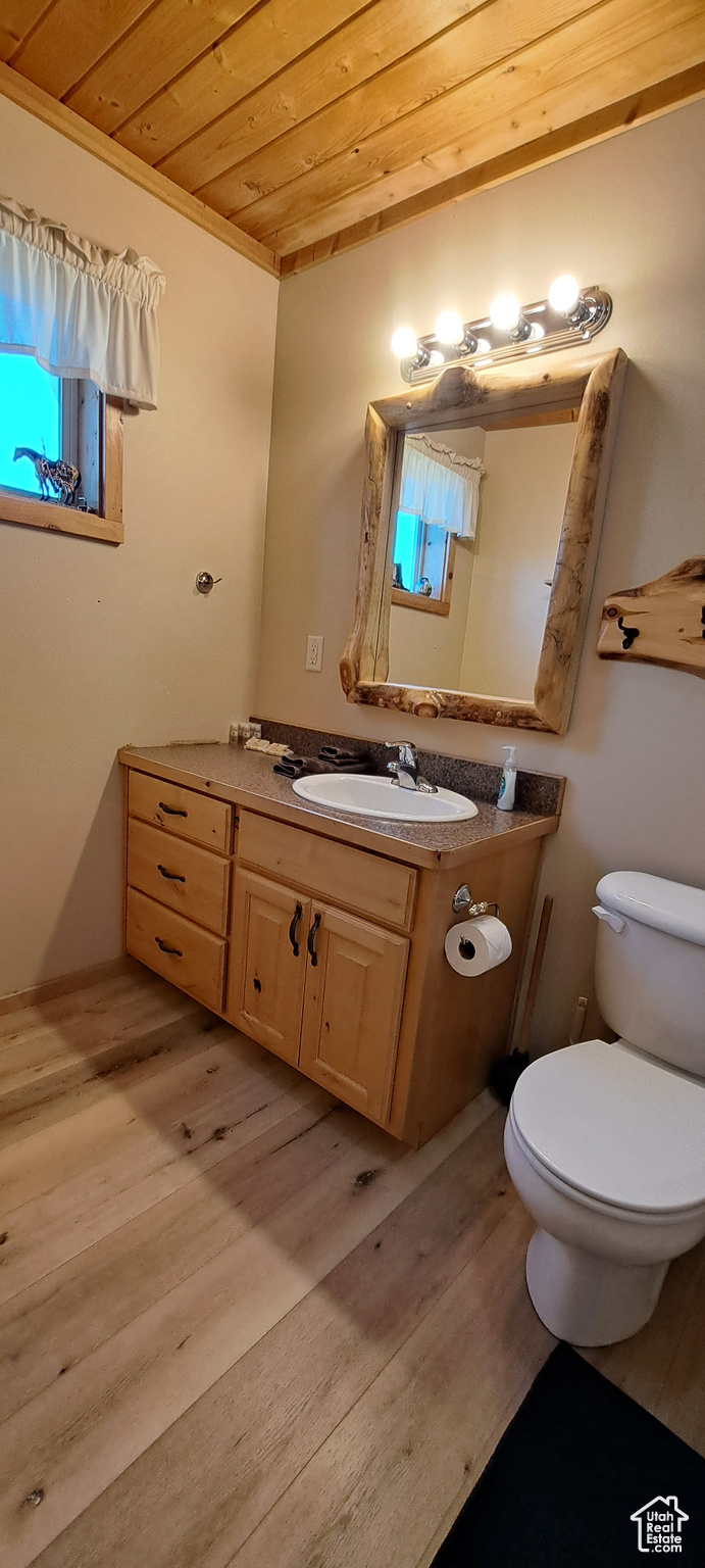 Bathroom with wood ceiling, vanity, crown molding, toilet, and hardwood / wood-style floors