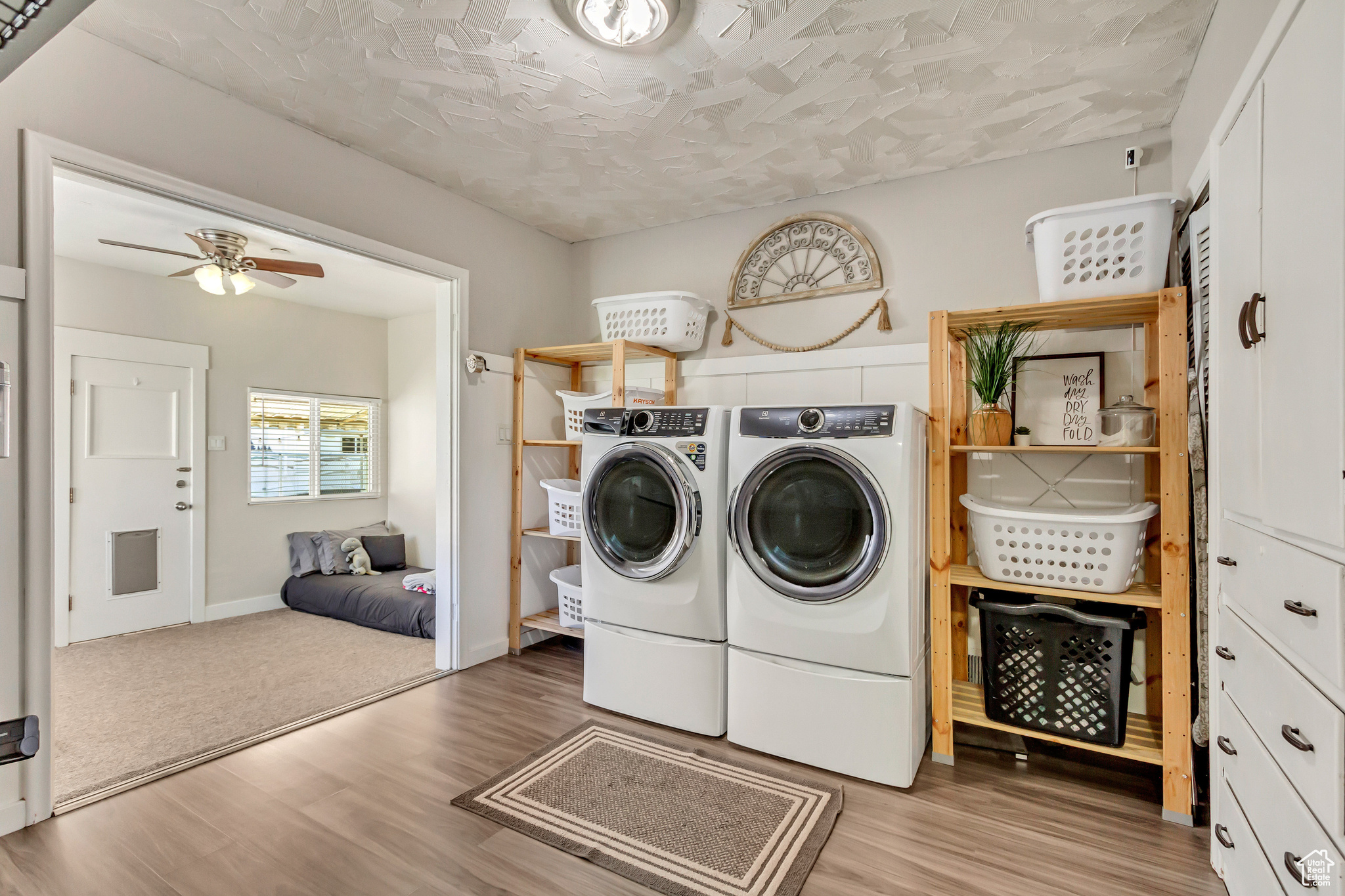 Clothes washing area featuring ceiling fan, a textured ceiling, light hardwood / wood-style flooring, and washing machine and dryer