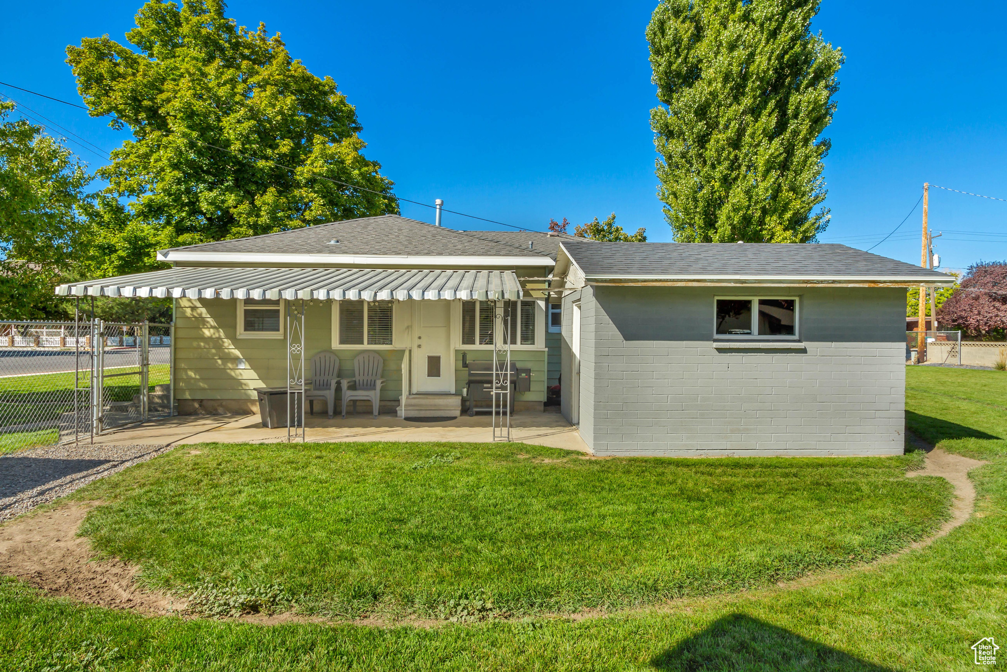 Rear view of property featuring a lawn and a patio